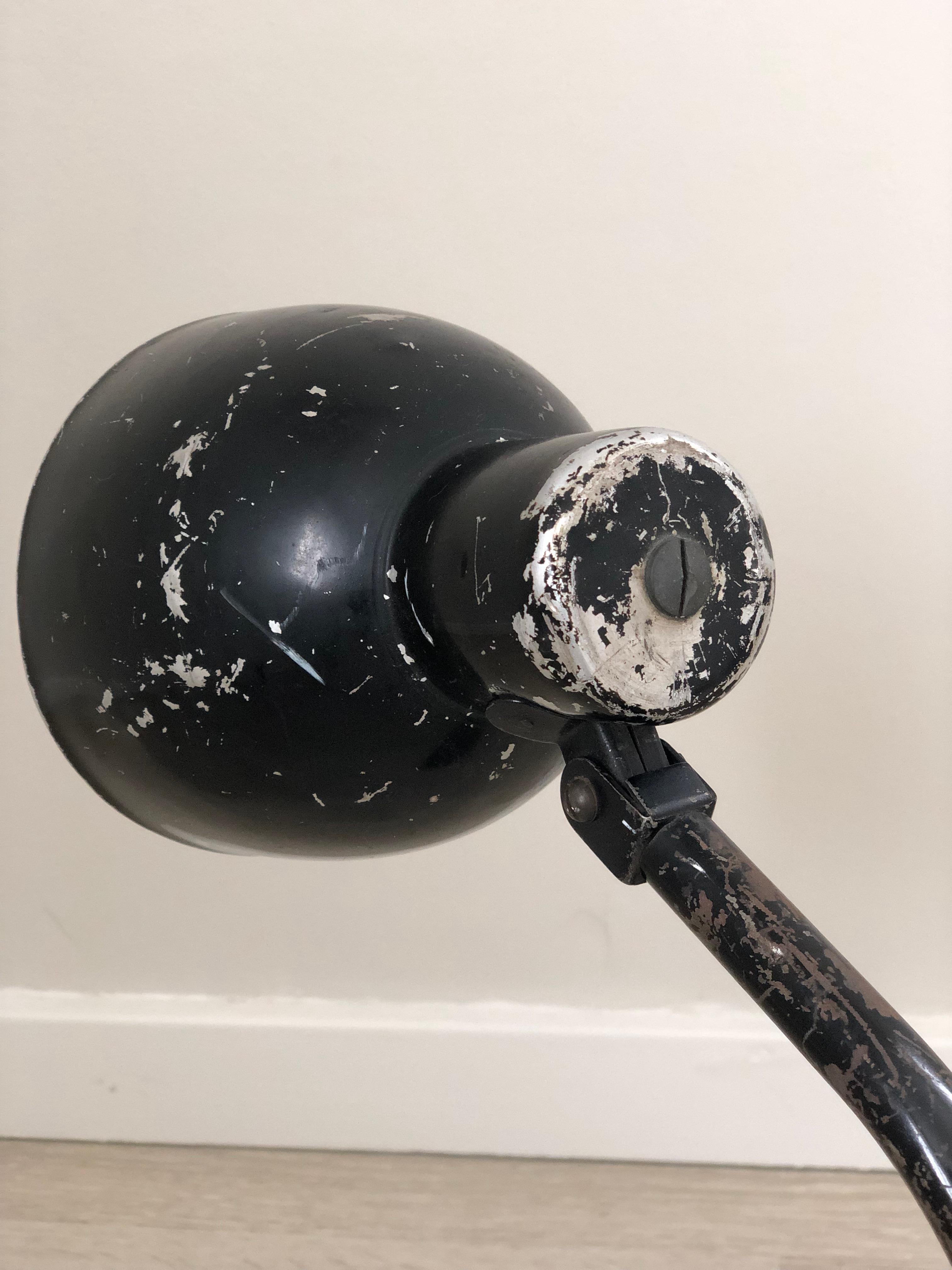 This industrial desk lamp from the 1940s is beautifully weathered. Designed with two pivot points and with a weighted base. In original condition from United Kingdom.

Object: desk lamp
Style: Industrial, Mid Century 
Period: 1940-1950
Country of
