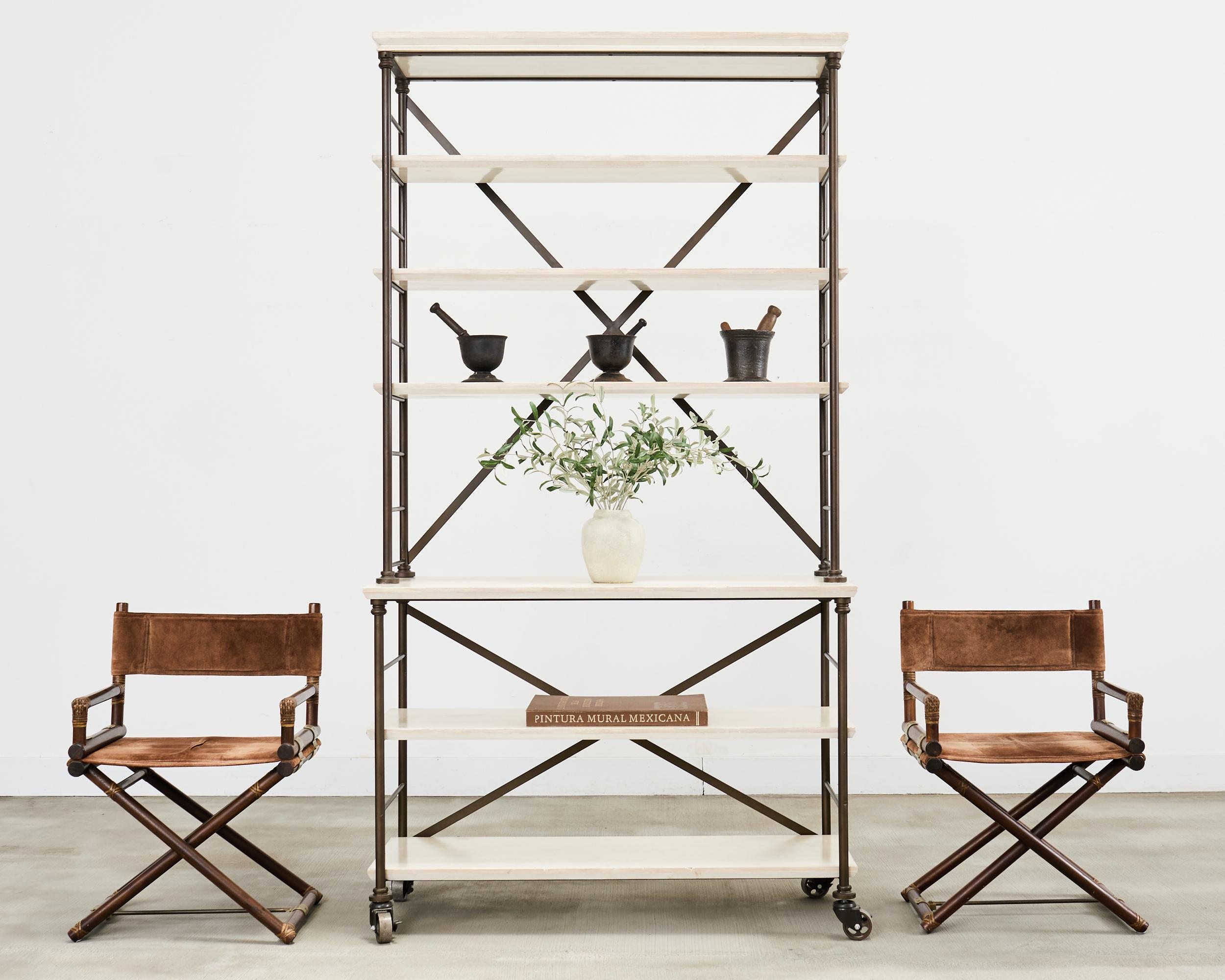 Rare industrial style rolling bookcase or etagere display shelf designed by Suzanne Kasler for Hickory Chair Furniture Company. The Prado bookcase features a large iron tubular frame with a rich dark bronzed finish. The bookcase is 2 part each