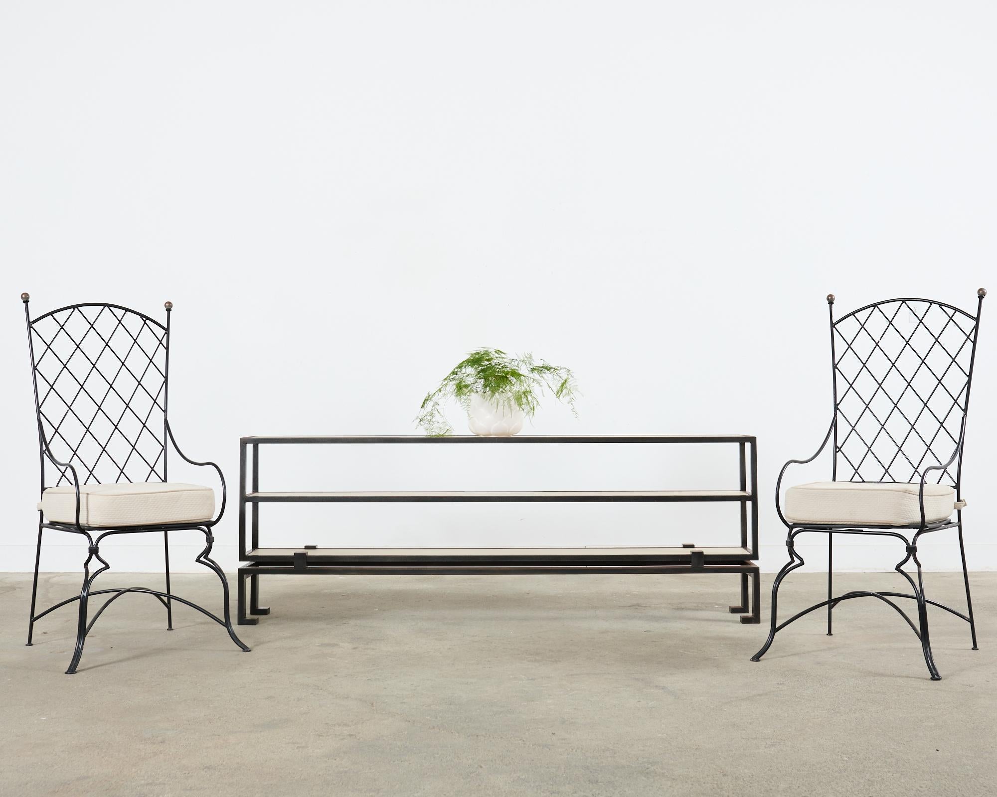 Large bespoke industrial style three tier console table featuring faux parchment leather shelves. The long console measures 7 feet long constructed from a thick iron frame with a patinated finish. The three shelf top is supported by a base with