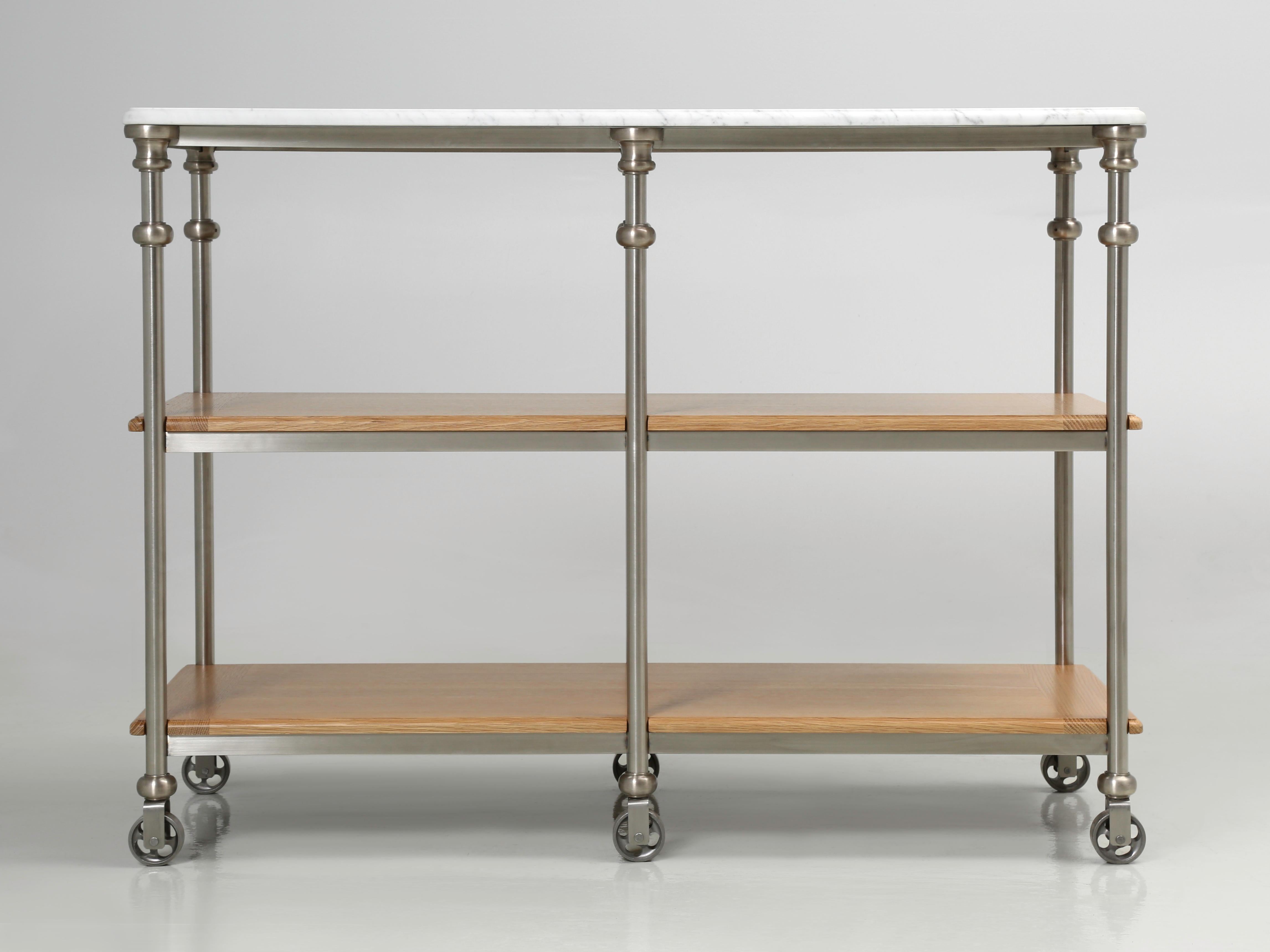 Isla de cocina de estilo industrial en acero inoxidable con herrajes de bronce plateado y encimera de mármol de Carrara.  Nuestra línea de islas de cocina Old Plank se fabrica aquí mismo, en Chicago, en prácticamente cualquier dimensión. Las