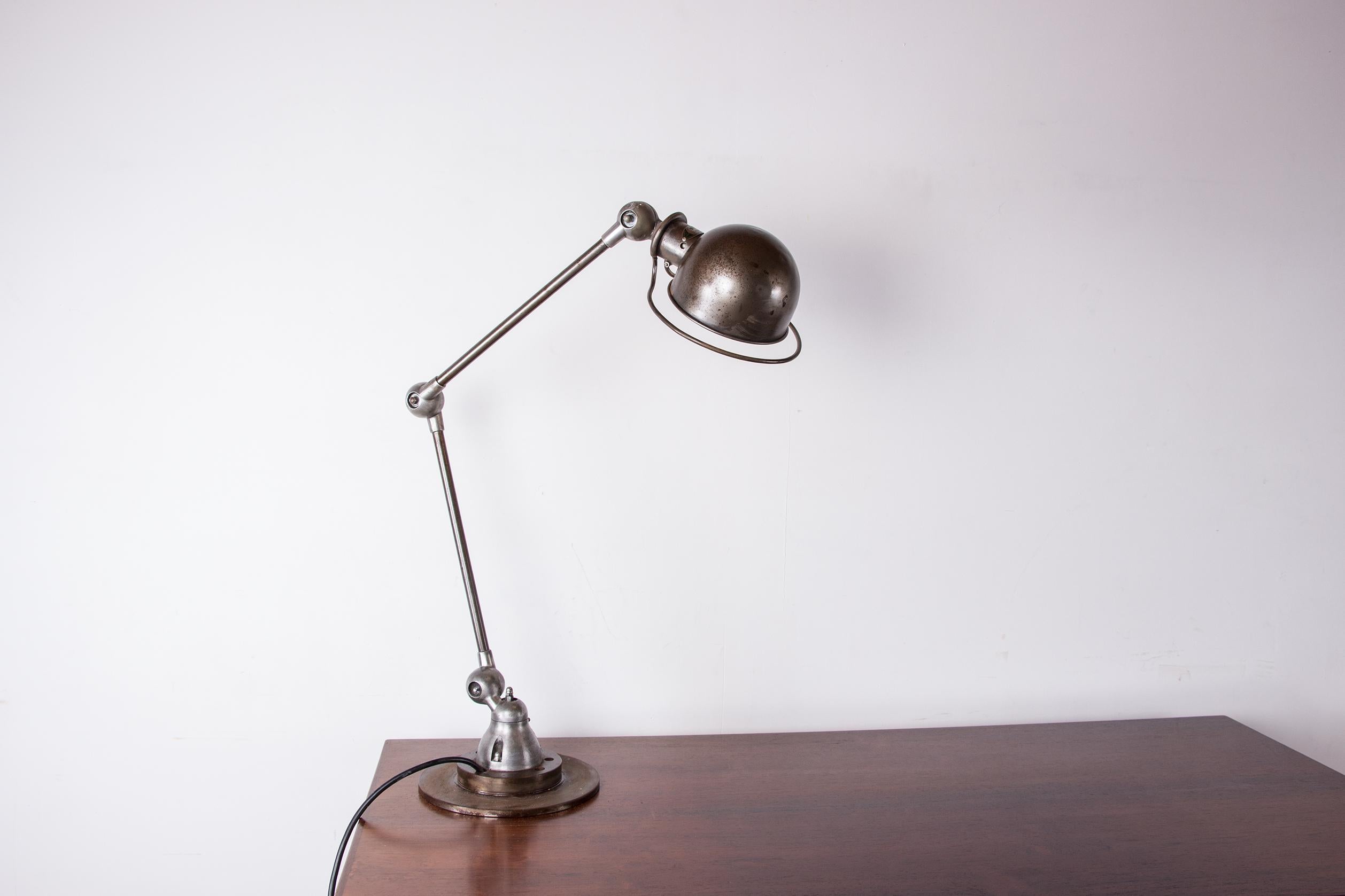 Hervorragende alte Schreibtischlampe. 
Diese ikonische Lampe im industriellen Stil hat eine sehr schöne Patina und eine perfekte Beleuchtung. 
Der Schalter befindet sich an der Lampe selbst. Der Lampenschirm und die Arme können dank eines kabellosen