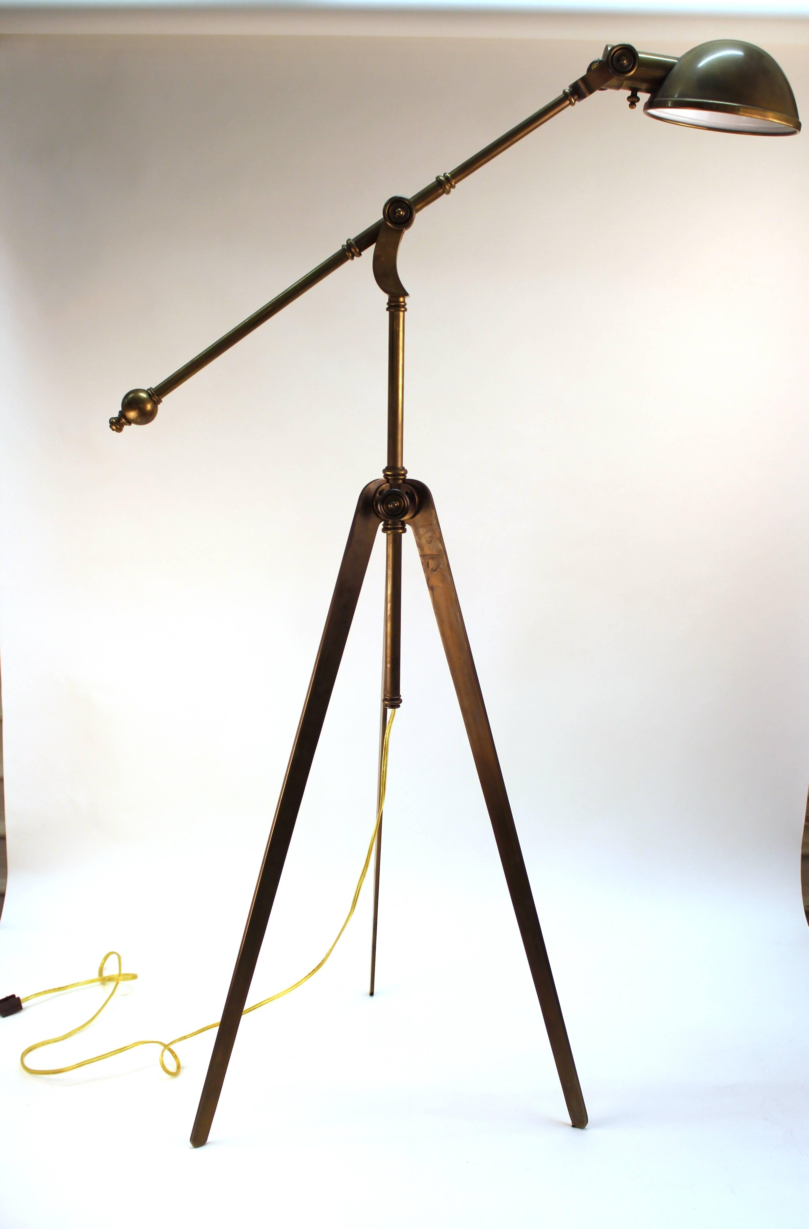 Standing reading lamp in brass. Features an adjustable neck on a tripod base. Wear appropriate to age and use. The lamp is in good condition.