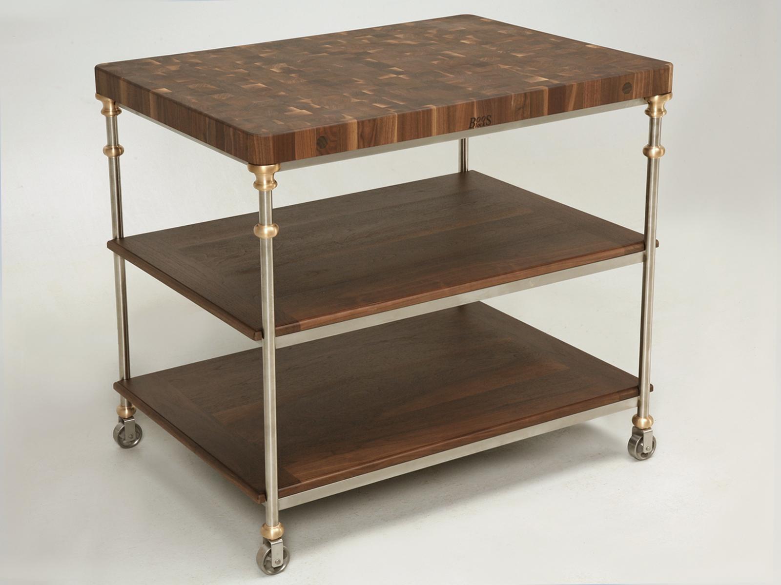 French Industrial Style Stainless Steel Kitchen Island, with a Boos Solid Walnut Butcher Block Yop and two solid walnut shelves. All of the fittings are solid bronze and the casters can be made either functional or locked permanently. Since we