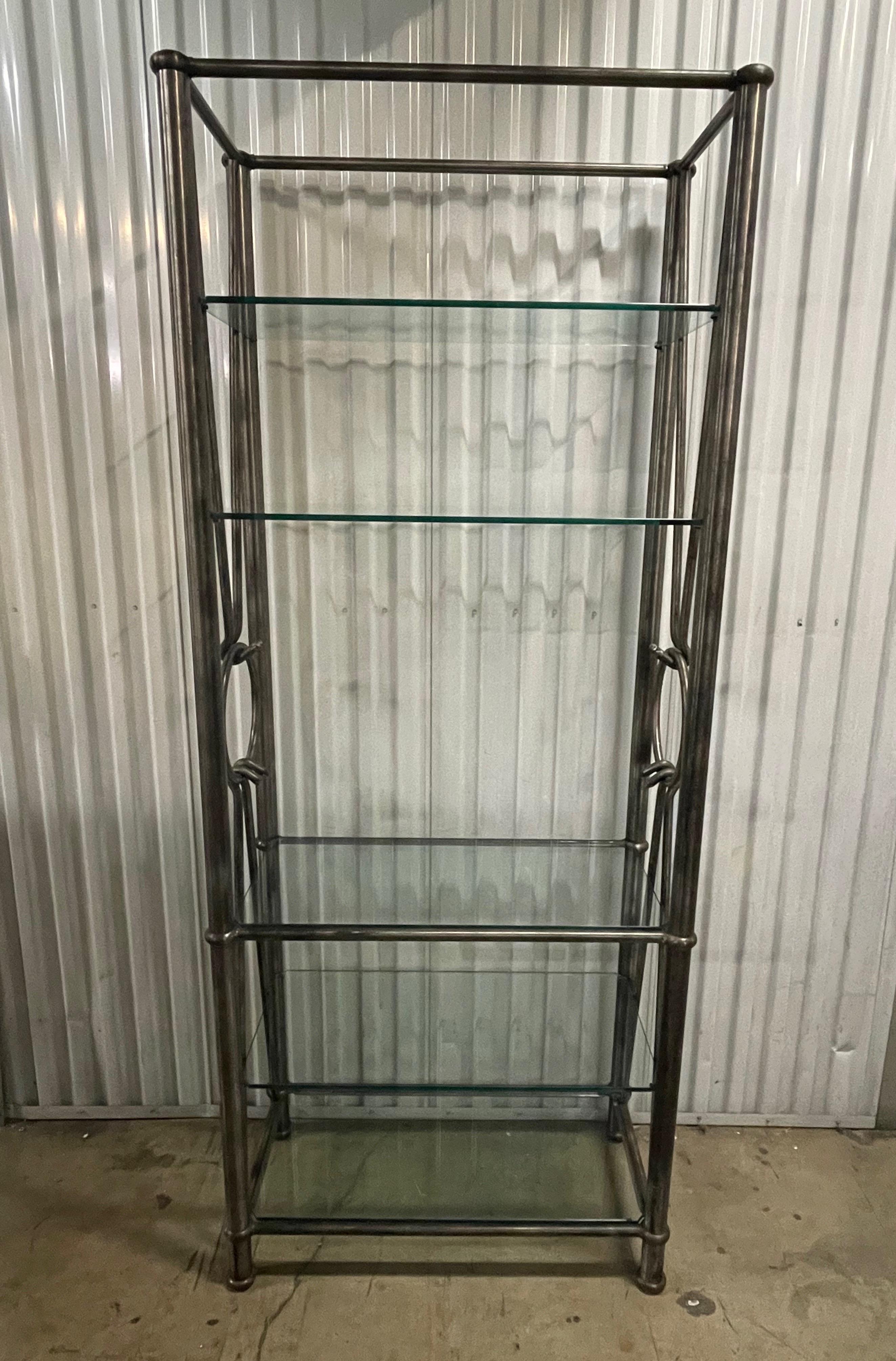 Brutalist style steel etagere with four glass shelves. Sides have a large circle in center with large hooks coming from both the top & bottom. A very unique & interesting piece.