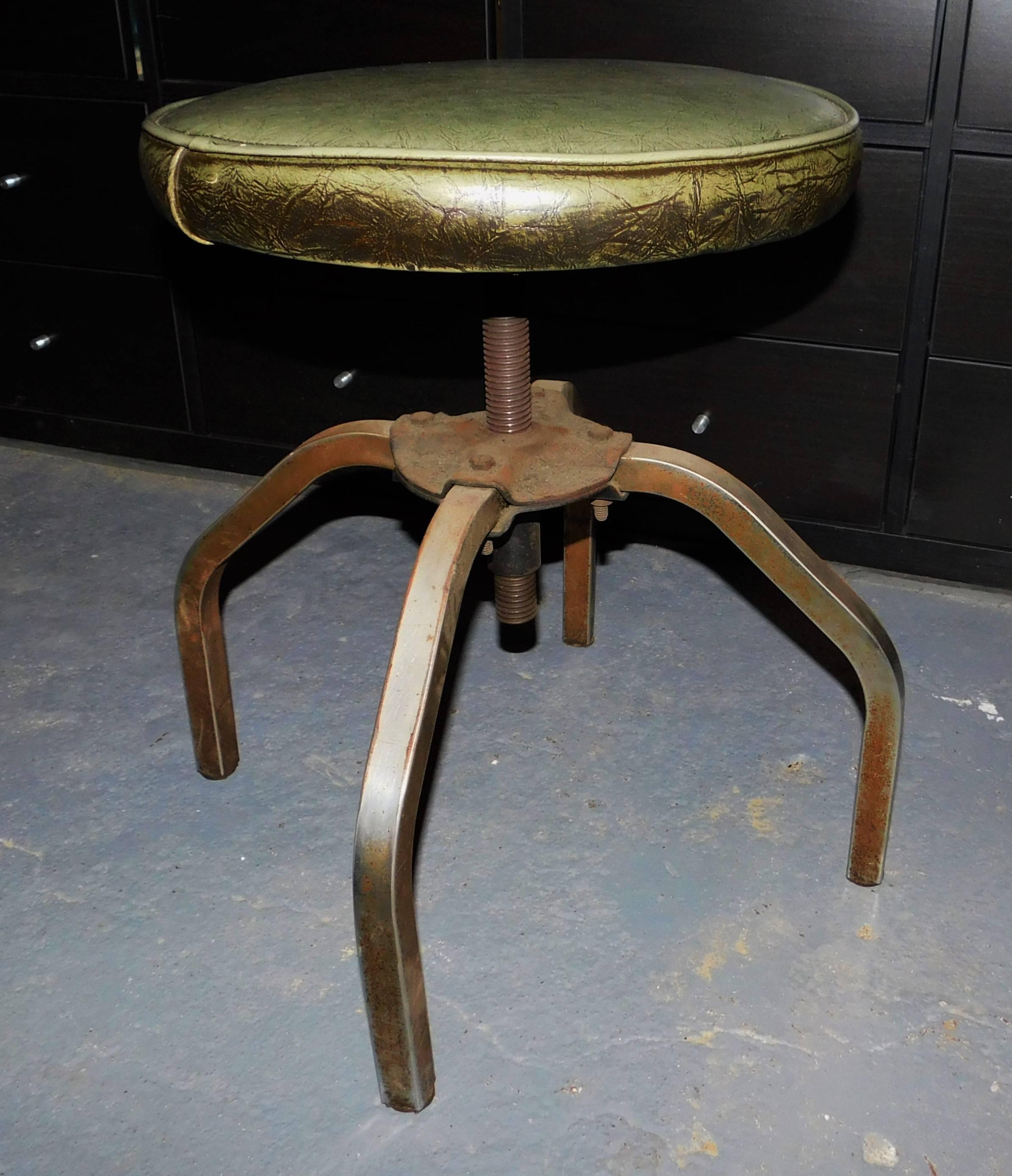 This circa 1940 swivel leather and metal stool could have been used by a dentist or doctor's office. It can be rotated to raise or lower the green leather seat.