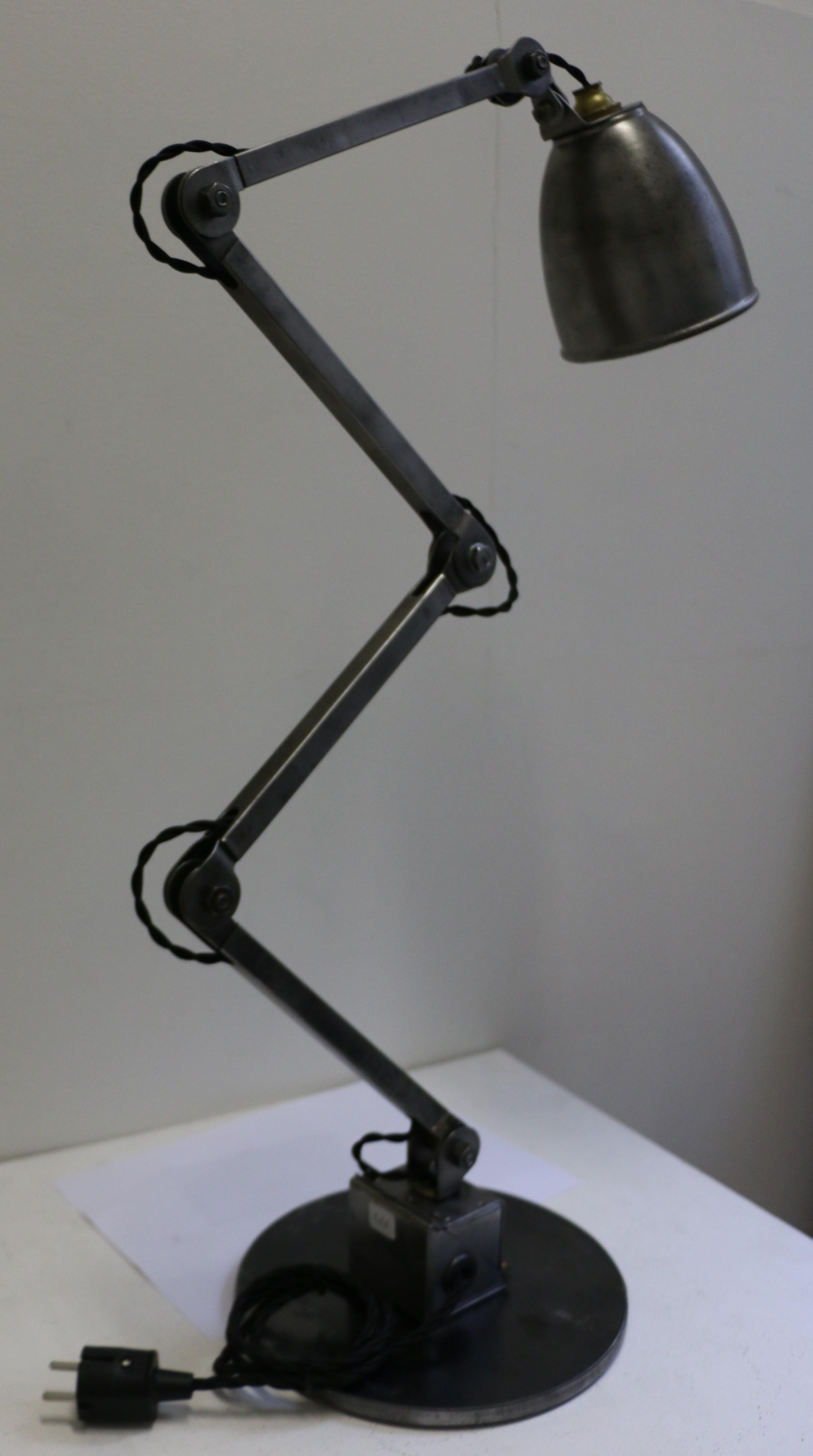 Industrial table lamp manufactured by E.D.L. circa 1950. This articulated steel lamp has been remounted on a round steel plate. Steel has been polished. It can be oriented in multiple positions. Very good condition. It has been rewired for European