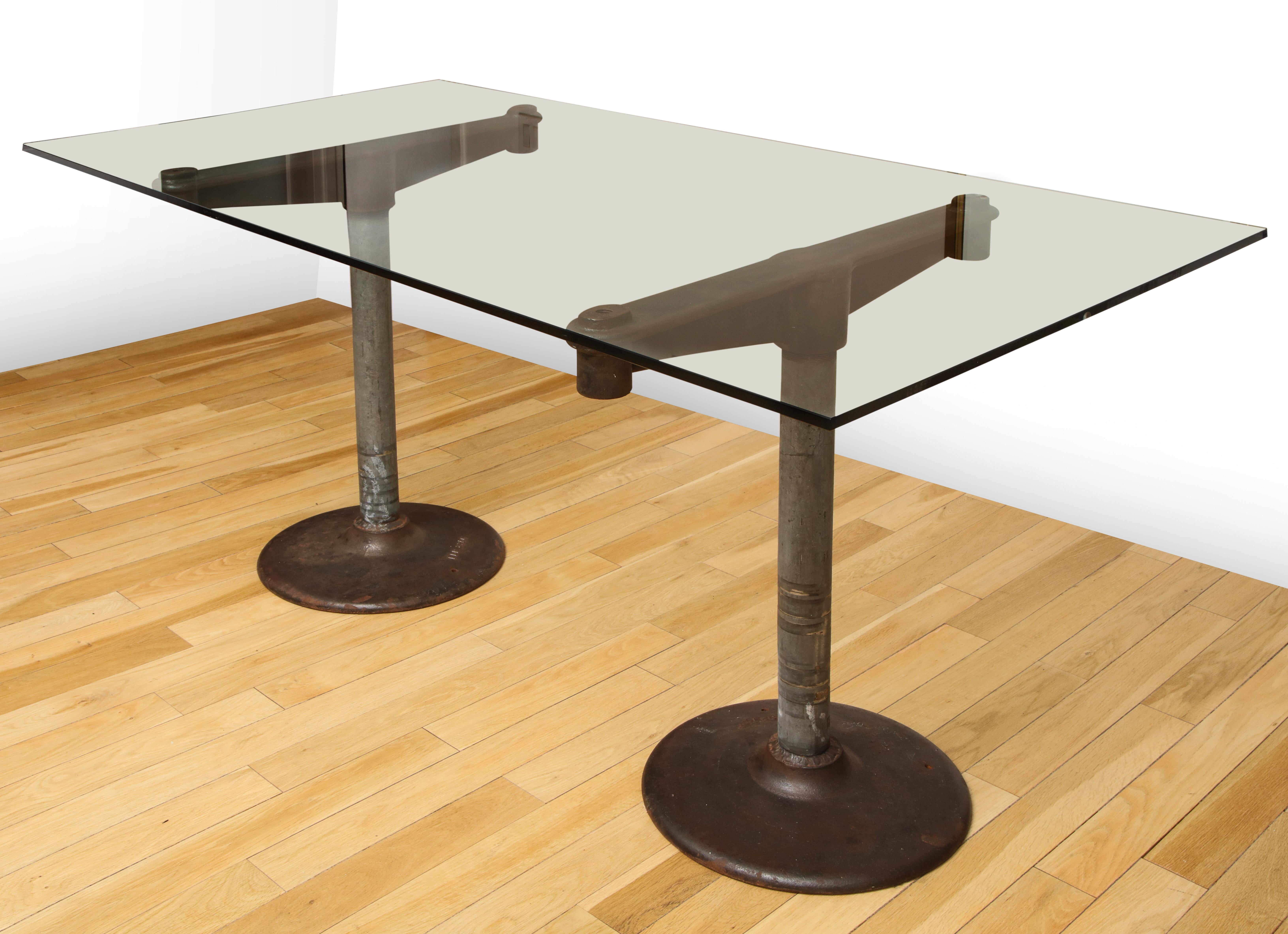 Industrial iron base table with 5' glass top from the 1950s. Supports are two separate pieces. Glass is new. 