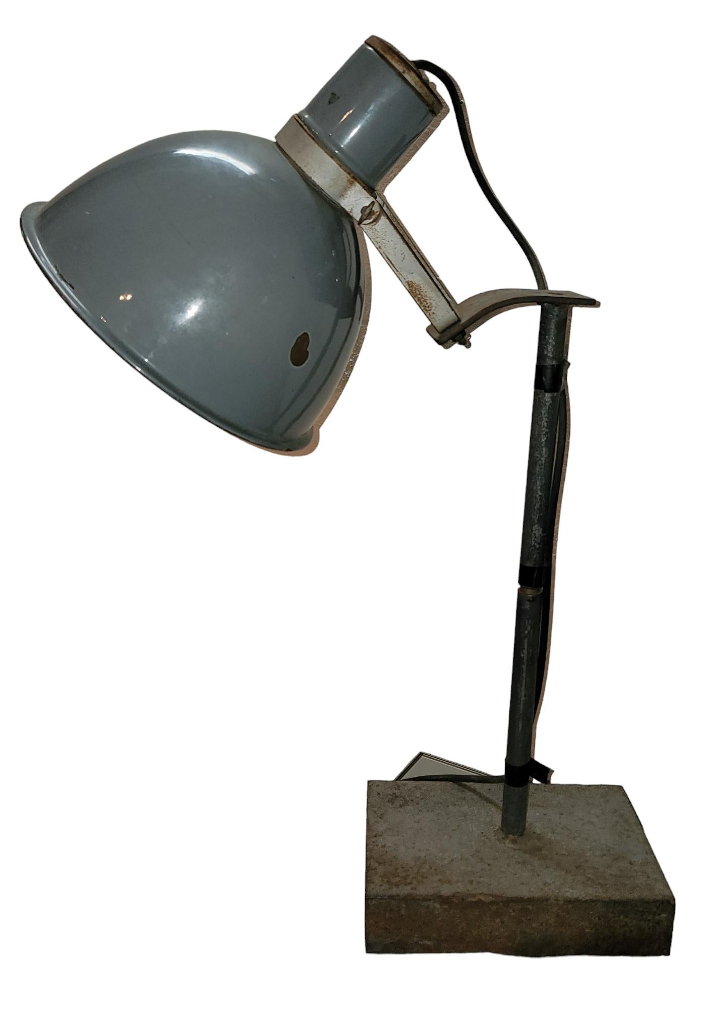 Industrielle Metalltischlampe mit schwerem Metallsockel. Der hohe Stiel ist aus Metall und der obere Schirm ist fest mit dem Stiel verbunden und kann verstellt werden.  ist ein dünnes Metall.  Maße 27h x 20w x 6d