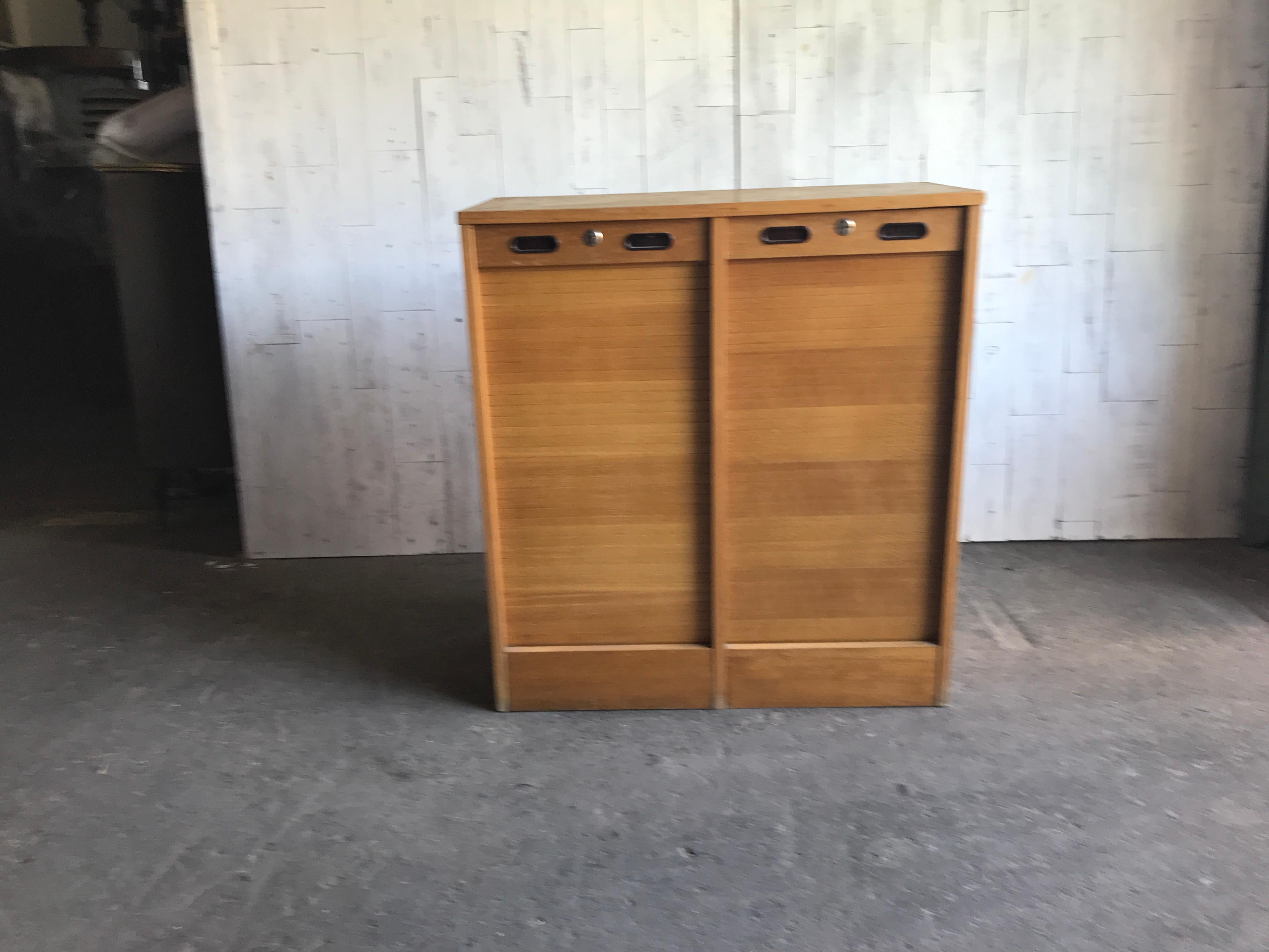 Industrial oak tambour front cabinet, 1950s.
Original good condition
Size: 83 x 91 x 39
Mid-20th century Industrial double tambour front haberdashery filing cabinet.