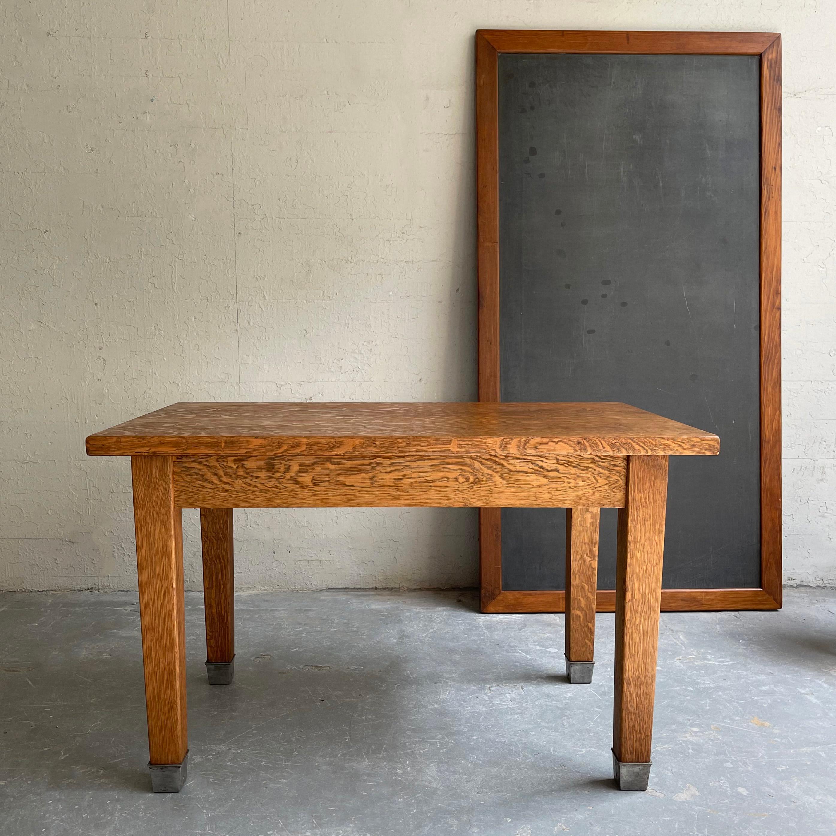 Industrial, midcentury, library table with fantastic, quarter sawn, Tiger oak grain throughout and steel capped legs is a flexible piece to use as a desk, dining or work table. The table apron is 24 inches height. Shown with Toledo stool and tall