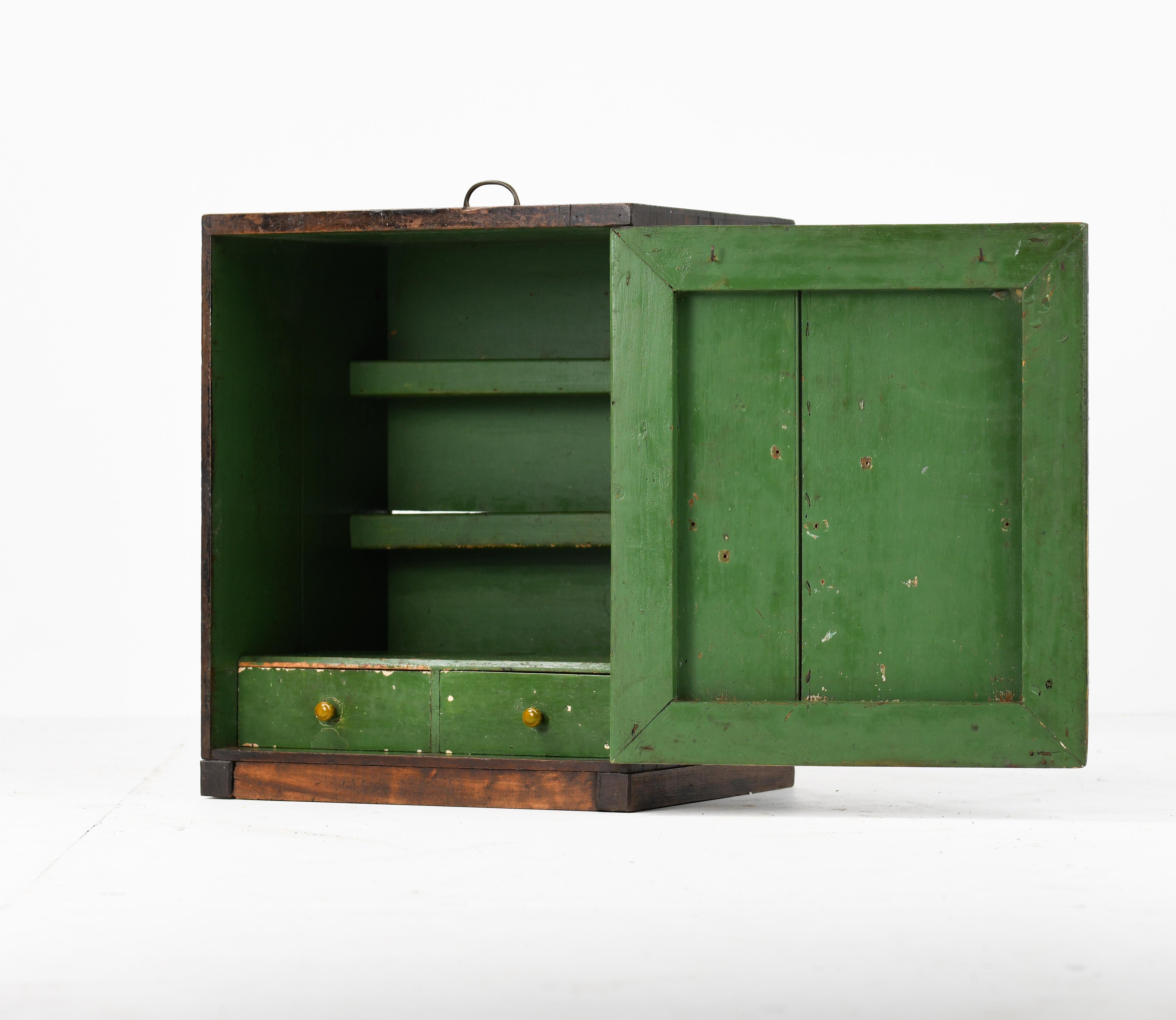 Solid teak Victorian tool cabinet plenty of patination to exterior and the paint green interior. Original carry brass carry handle two drawers inside and two shelves. Practical side table cabinet cleaned & waxed to give a good luster to the wood
