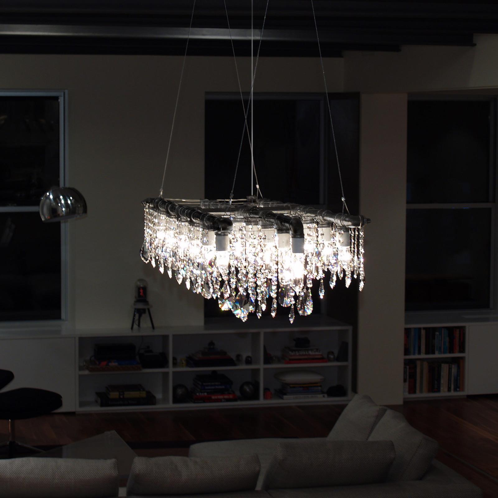 The Industrial Triple Rail Chandelier is undoubtedly one of our most ambitious designs to date. Its design is both simple – with three steel pipe rails and a crossbar – and richly complex, with rows of optically-pure crystal alternating with
