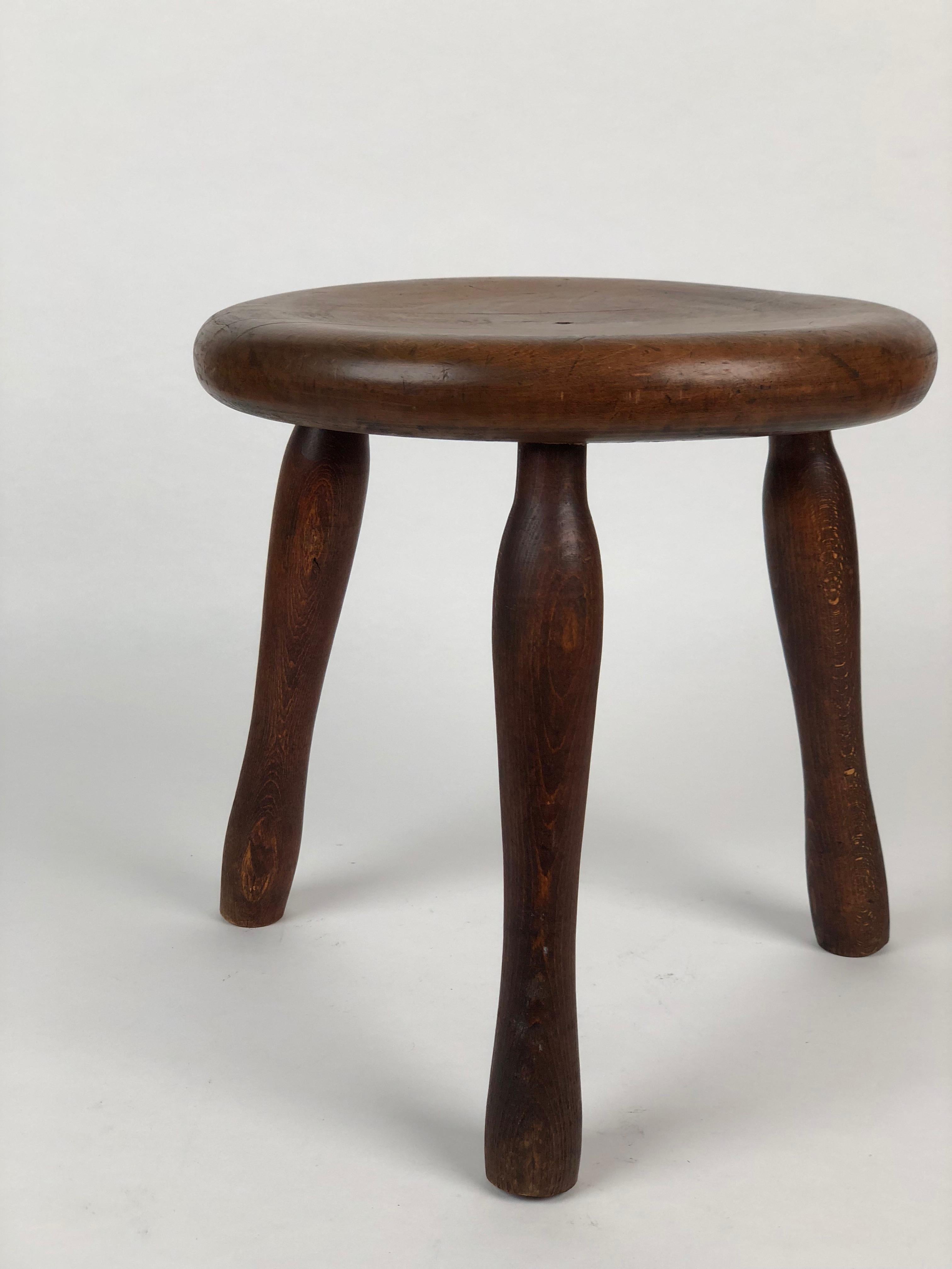 A small three-legged industrial stool with a seat made out of walnut and the three legs from stained beechwood.
The whole in the middle of the seat was for a cushion with a pin that went through the hole to keep it from slipping.
The finish is the
