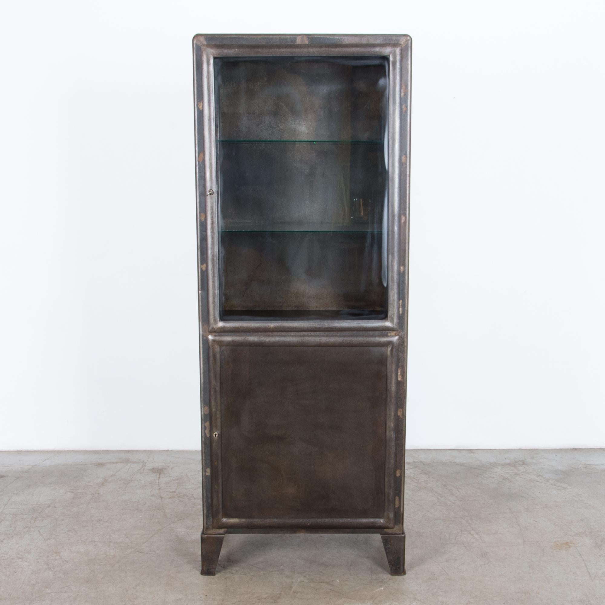 A two door metal vitrine from Czech Republic circa 1930. This polished steel cabinet was
originally designed for industrial use, it features durable locking hardware and purpose built steel construction. The glass interior shelves, and textured