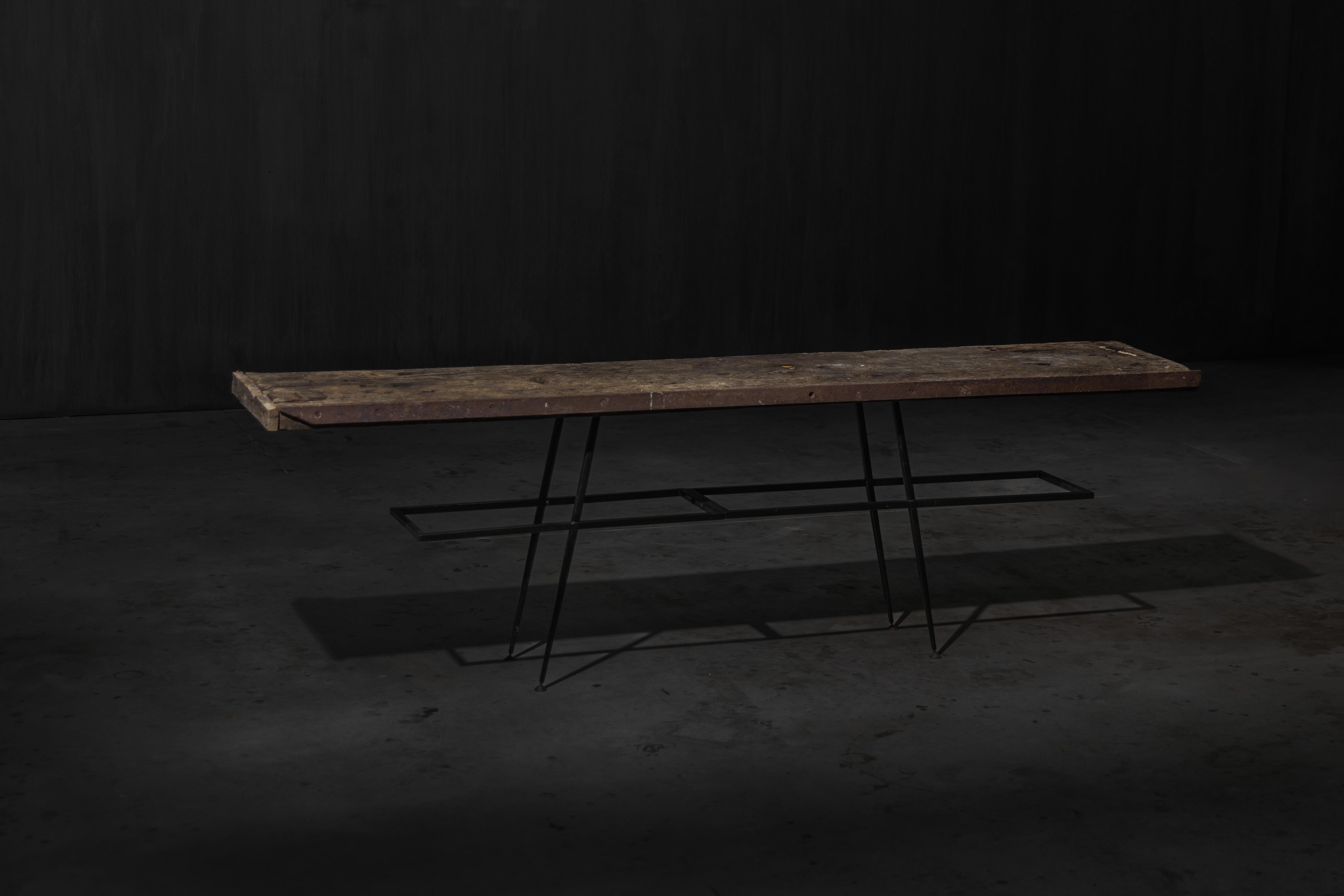 This one-of-a-kind atelier table pairs the quiet strength of reclaimed oak with the stark precision of blackened steel. Its top is crafted from reclaimed solid oak, richly textured and naturally worn, bearing a beautiful patina that speaks to its