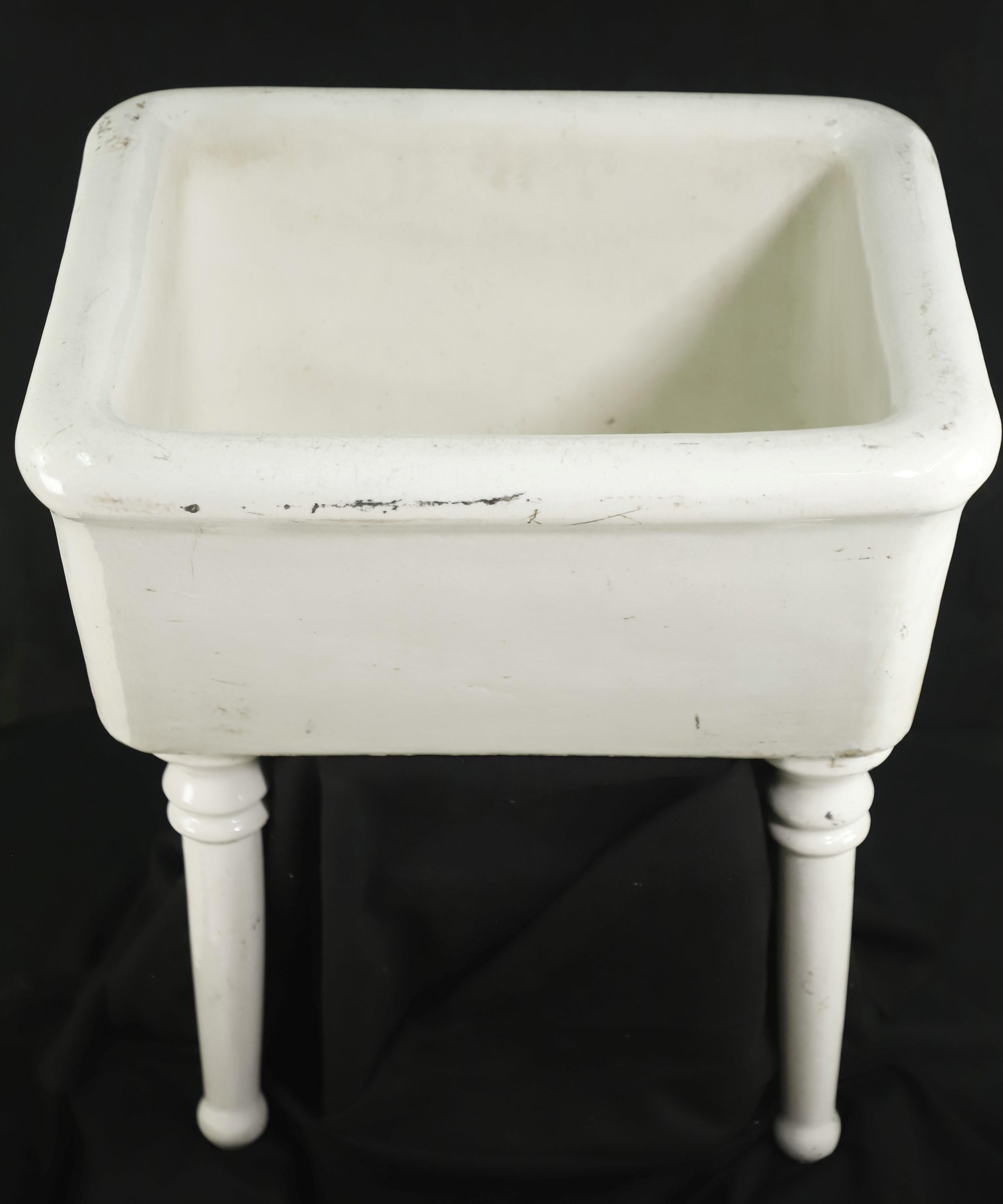 Early 20th Century large white earthenware wall mount slop sink supported by two front legs. Please note, this item is located in our Scranton, PA location.
