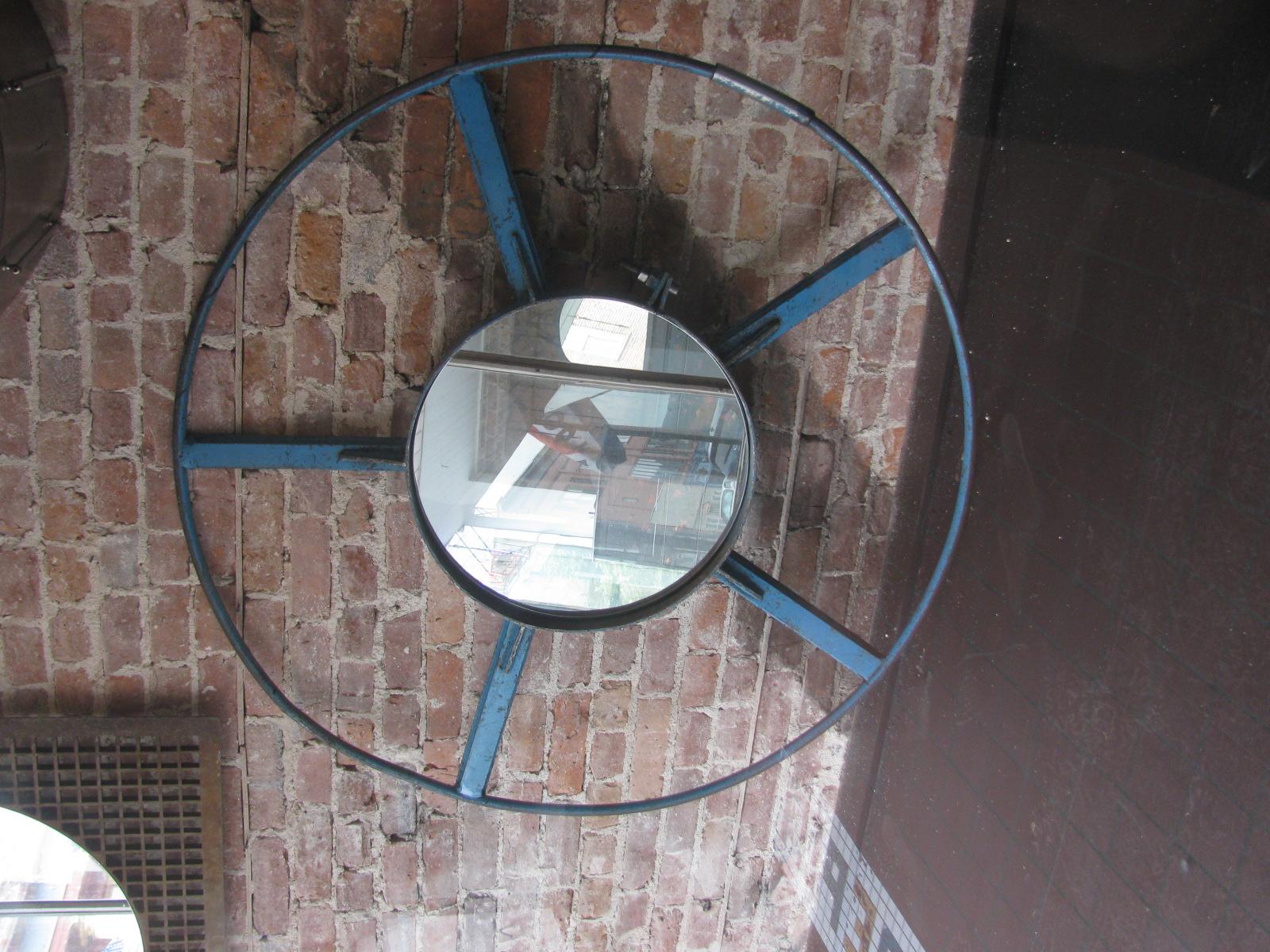 Spectacular mirror created from a Industrial wheel in fabulous blue paint. All original with a new piece of mirror custom fitted for the part. Mirror is 19.5 in diameter and projects 2.25 in. from the wall when hung. Has two mounting brackets for