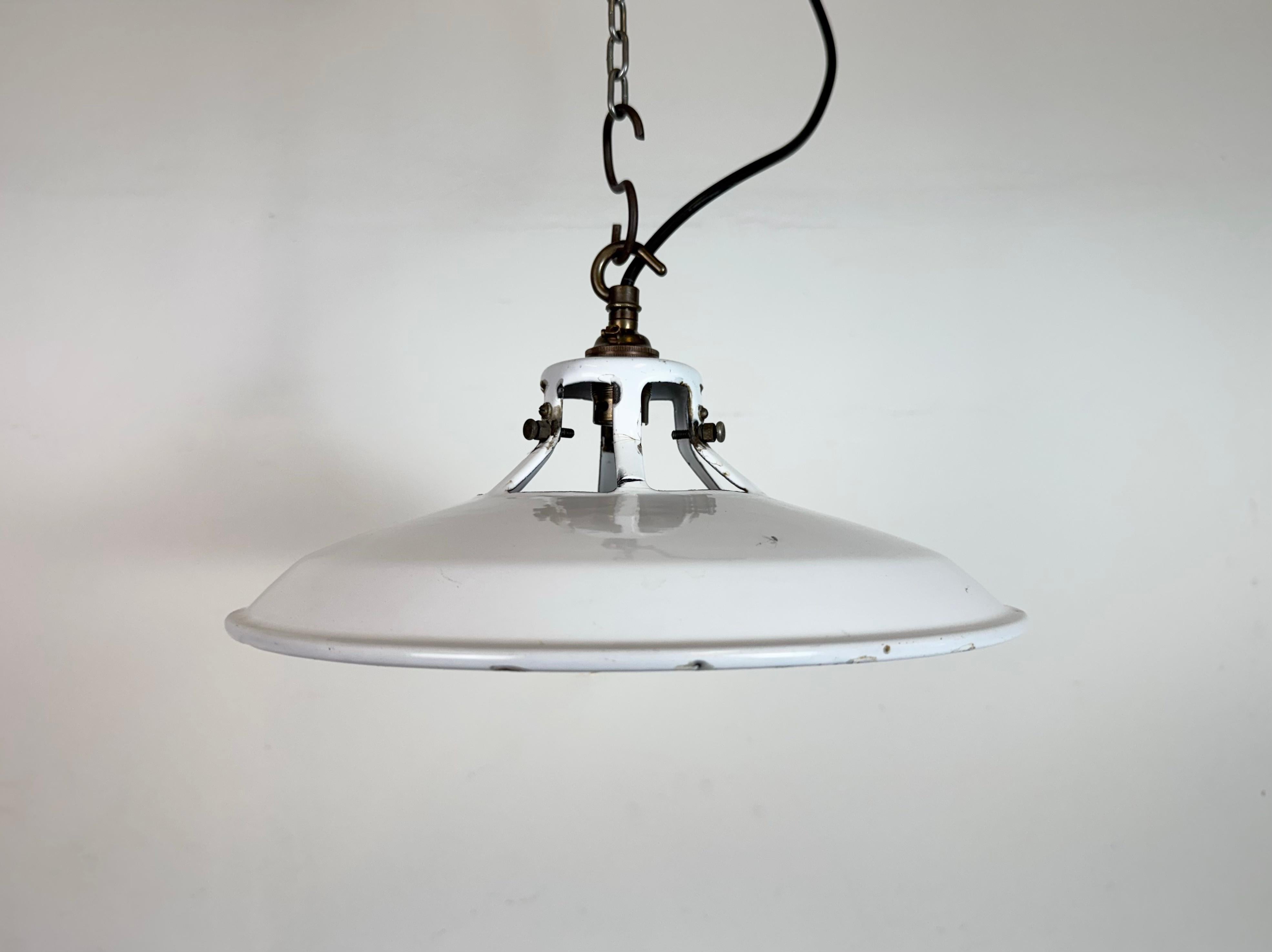 Suspension industrielle en émail blanc fabriquée au Royaume-Uni dans les années 1960. Émail blanc à l'intérieur de la teinte. Dessus en laiton. La douille est compatible avec les ampoules B22. Un nouveau fil. Le poids de la lampe est de 0,6 kg. Le