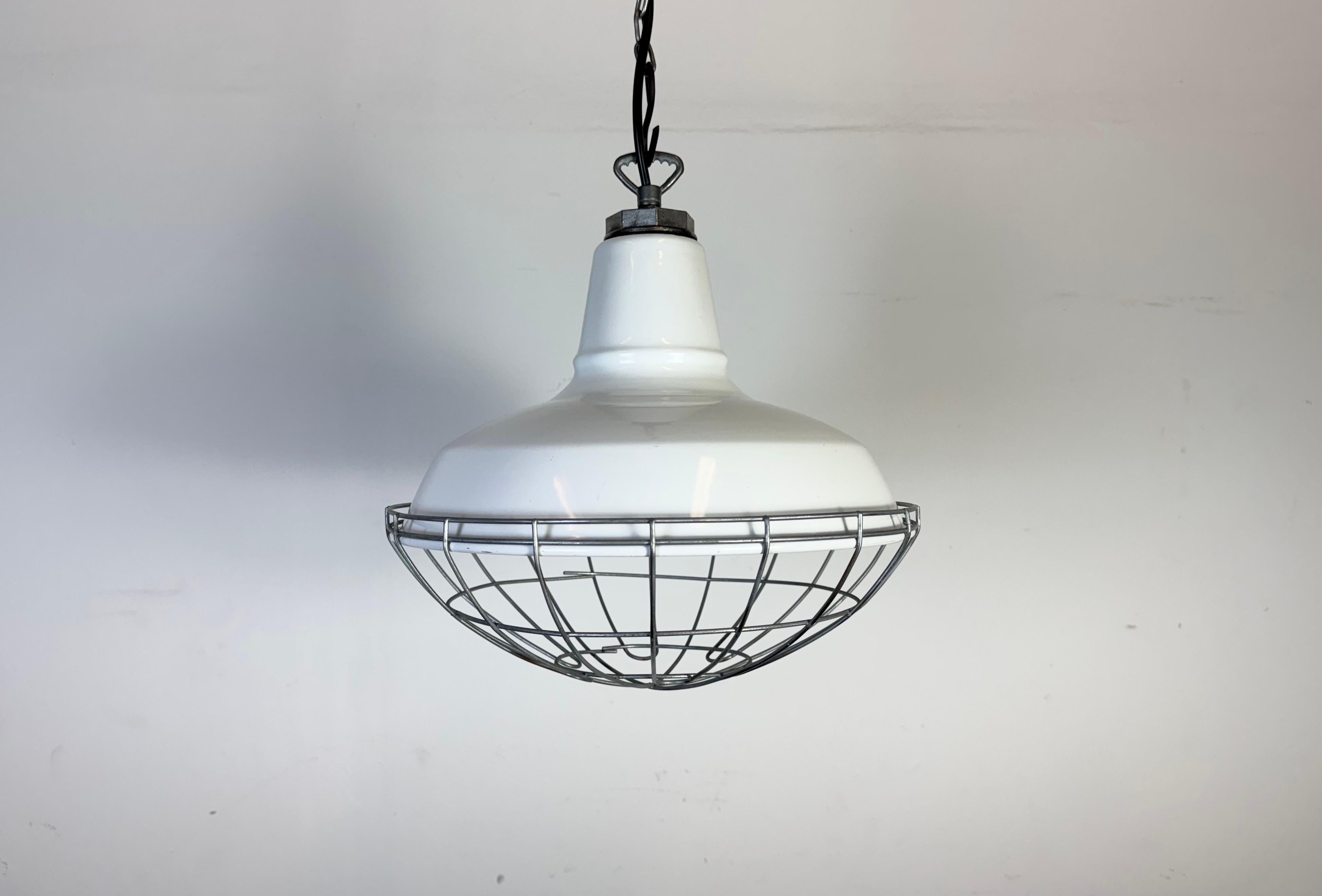 Lampada a sospensione industriale in smalto bianco realizzata da Benjamin negli Stati Uniti durante gli anni '60. Smalto bianco all'interno del paralume. Piano e griglia in ferro. L'attacco richiede lampadine standard E27/E26. Un nuovo cavo. Il peso