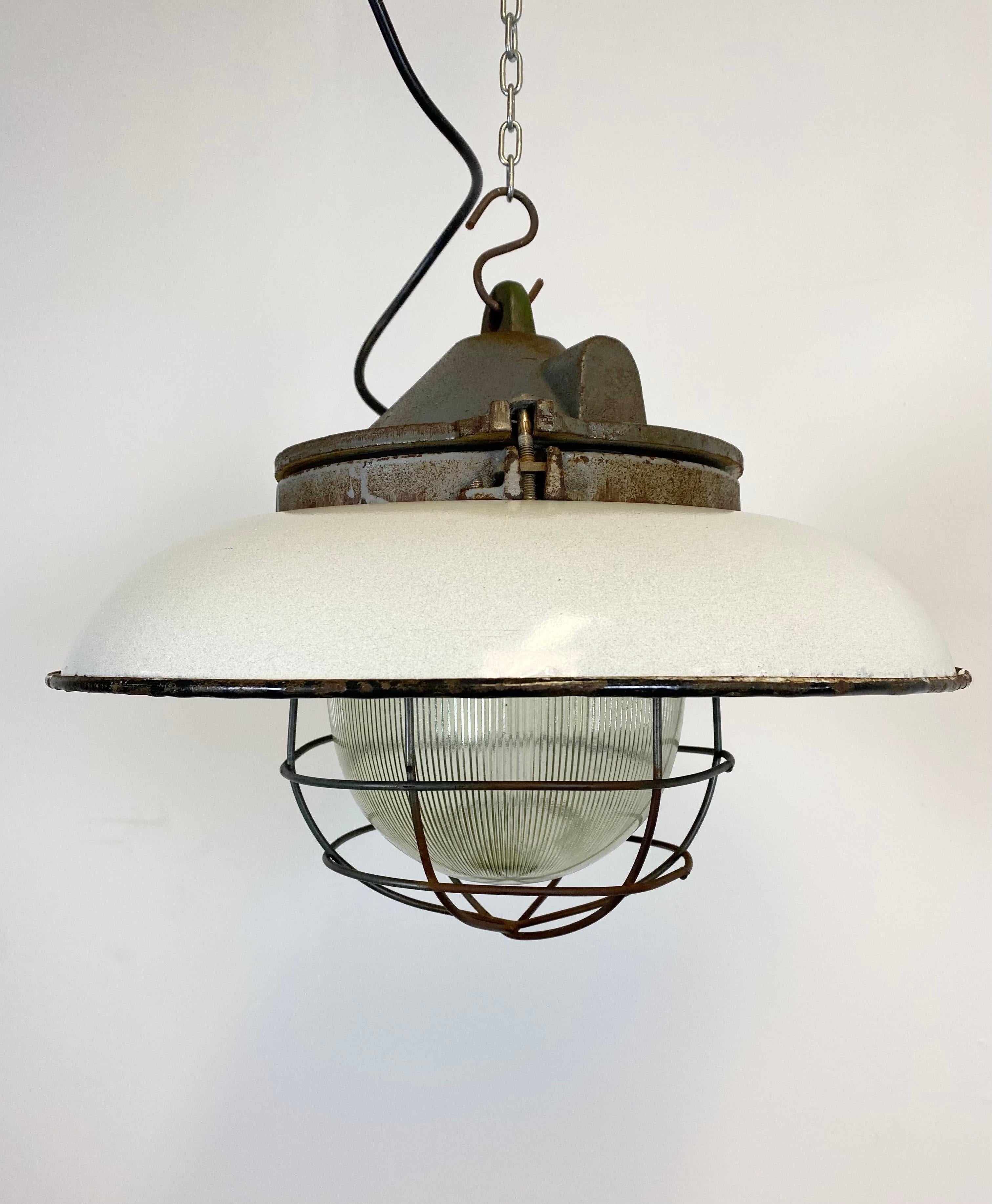- Industrial factory pendant lamp in cast iron
- Manufactured in the 1950s
- White enamel shade and iron grid
- Holophane glass
- Weight: 6.0 kg.