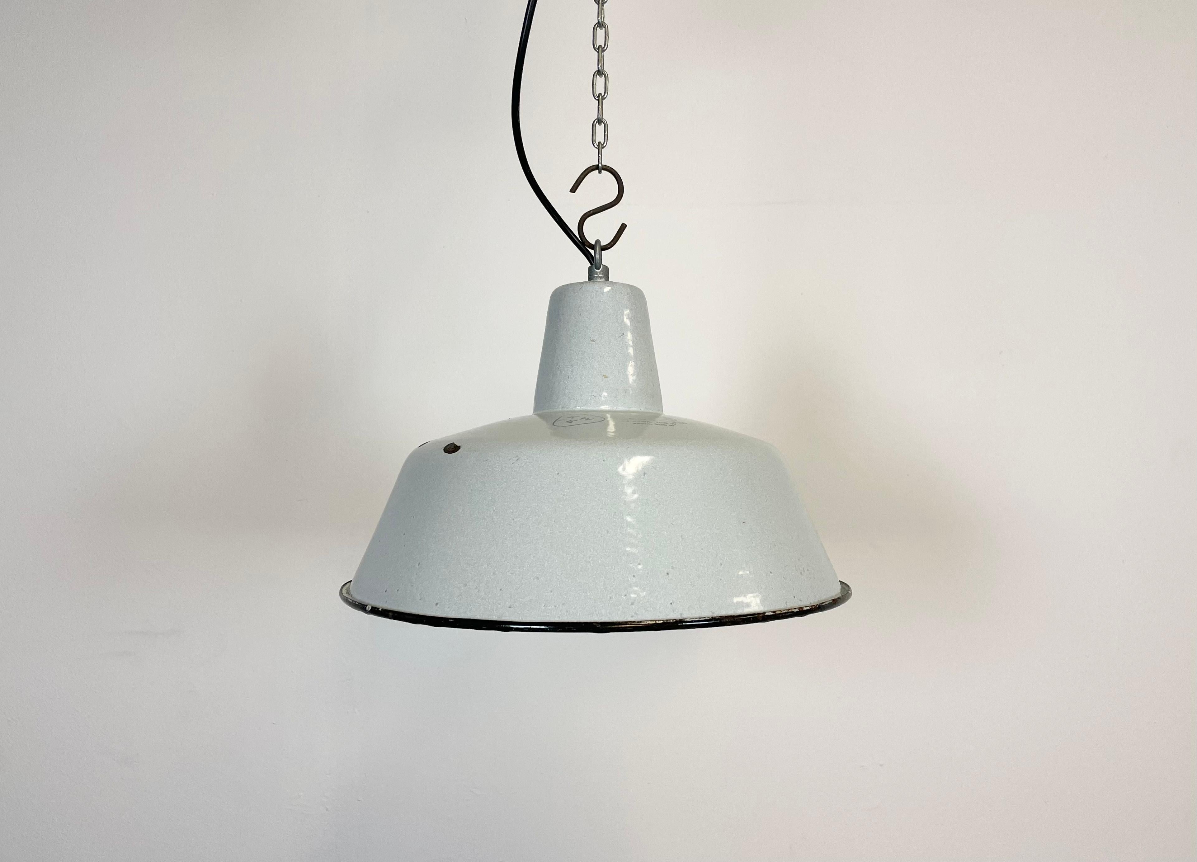 Industrial white enamel pendant light made by KWE in Poland during the 1960s. White enamel inside the shade. Iron top. The porcelain socket requires E 27 light bulbs. New wire. Fully functional. The weight of the lamp is 1,2 kg.