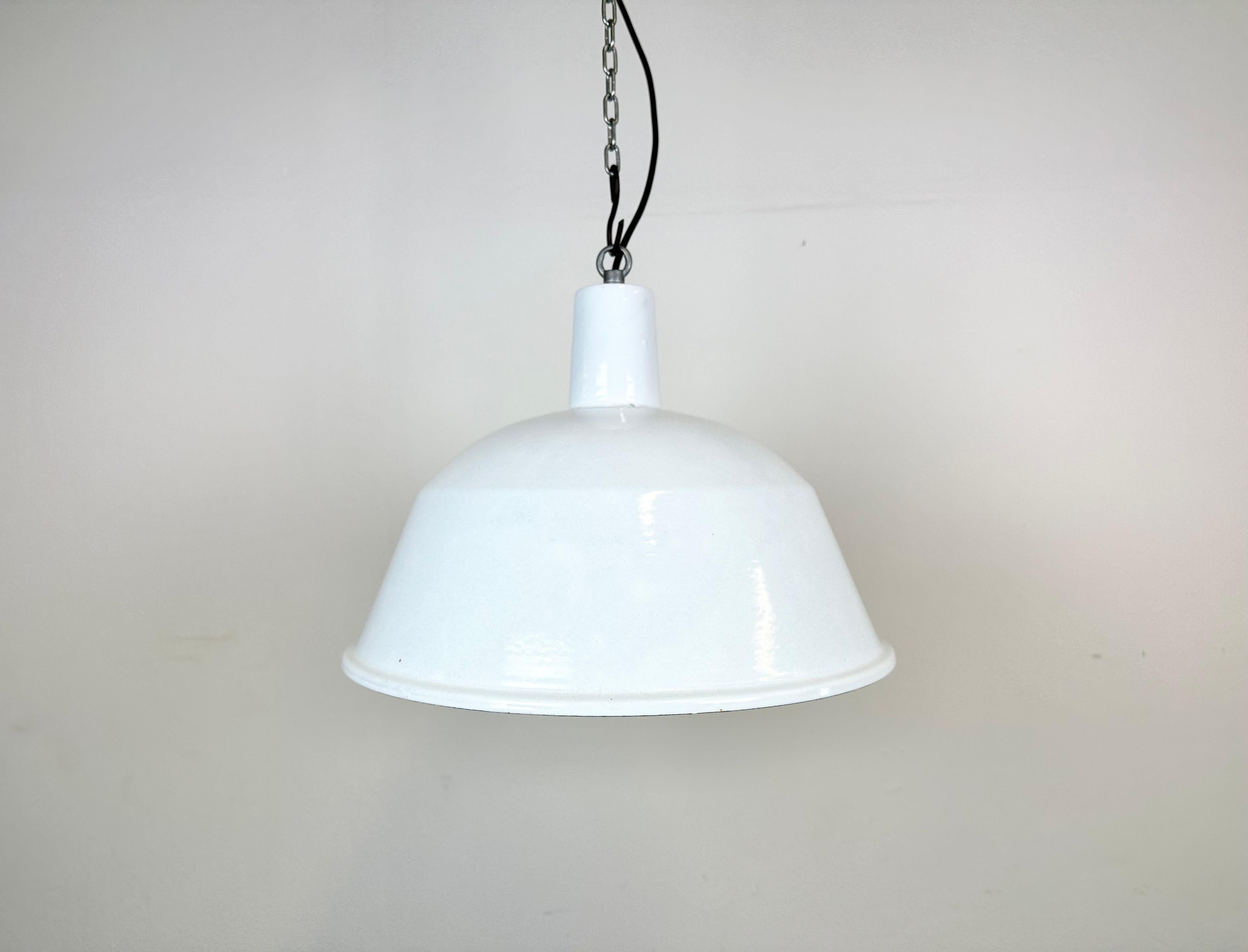 This industrial lamp was made by EMAX in Hungary during the 1960s. It features a white enamel shade with white enamel interior and iron top. New porcelain socket requires E 27/ E26 light bulbs. New wire. The weight of the lamp is 1,3 kg.