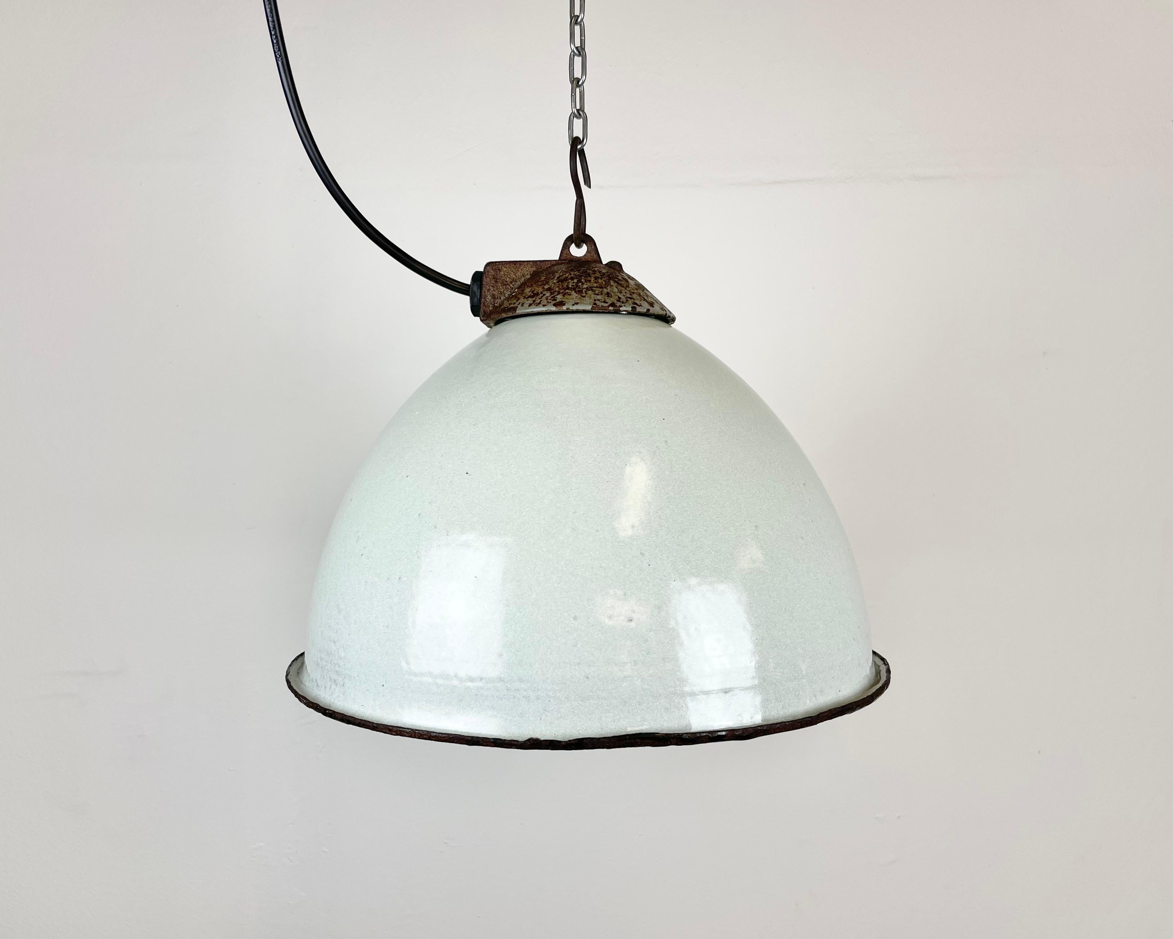 Industrial white grey enamel pendant light made by Zaos in Poland during the 1960s. White enamel inside the shade. Cast iron top. The porcelain socket requires E 27/ E26 light bulbs. New wire. Fully functional. The weight of the lamp is 1,8 kg.