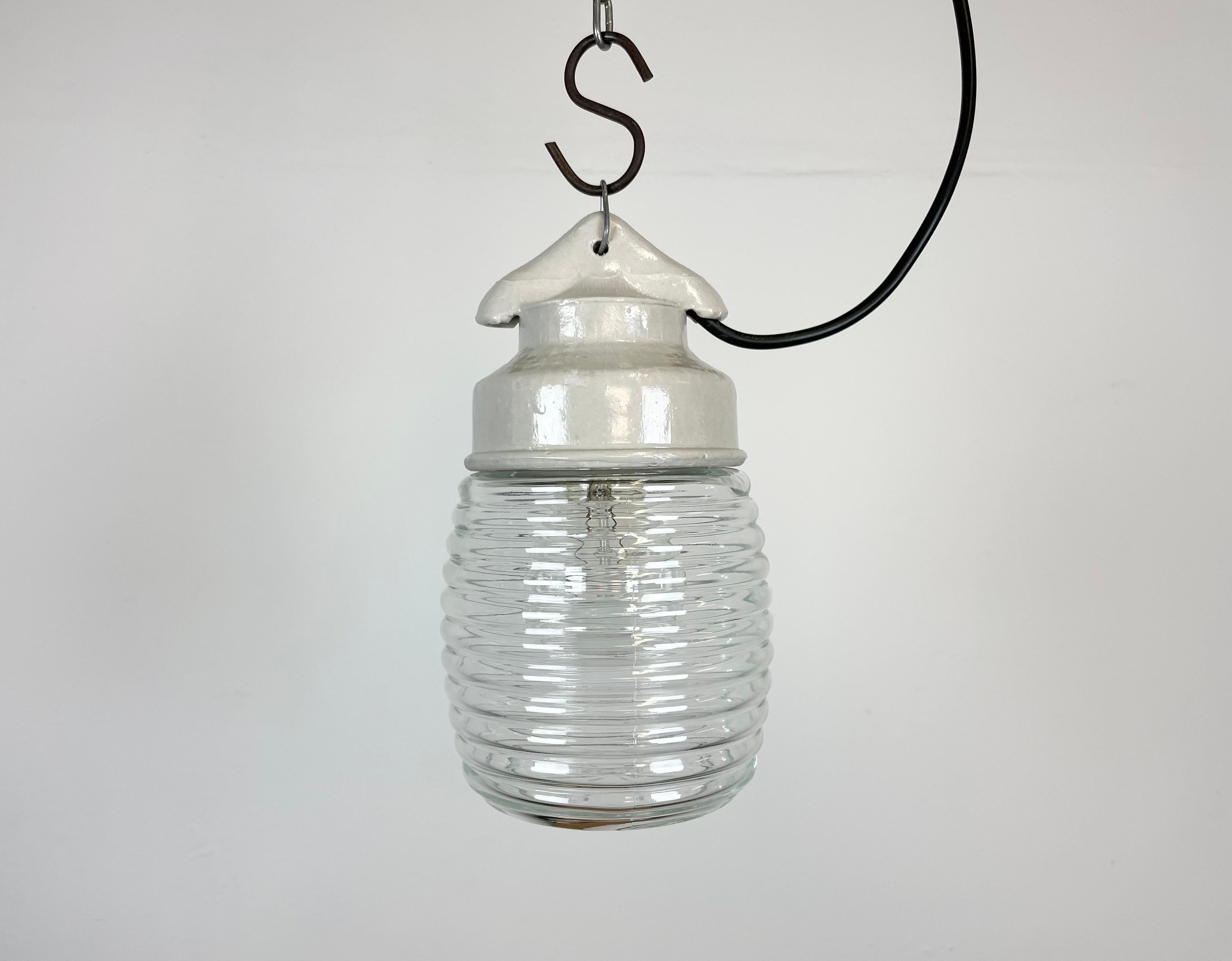 Vintage industrial light made in former Soviet Union during the 1970s.It features white porcelain top and stripped clear glass cover. The socket requires E27 light bulbs. New wire. The weight of the lamp is 1kg.