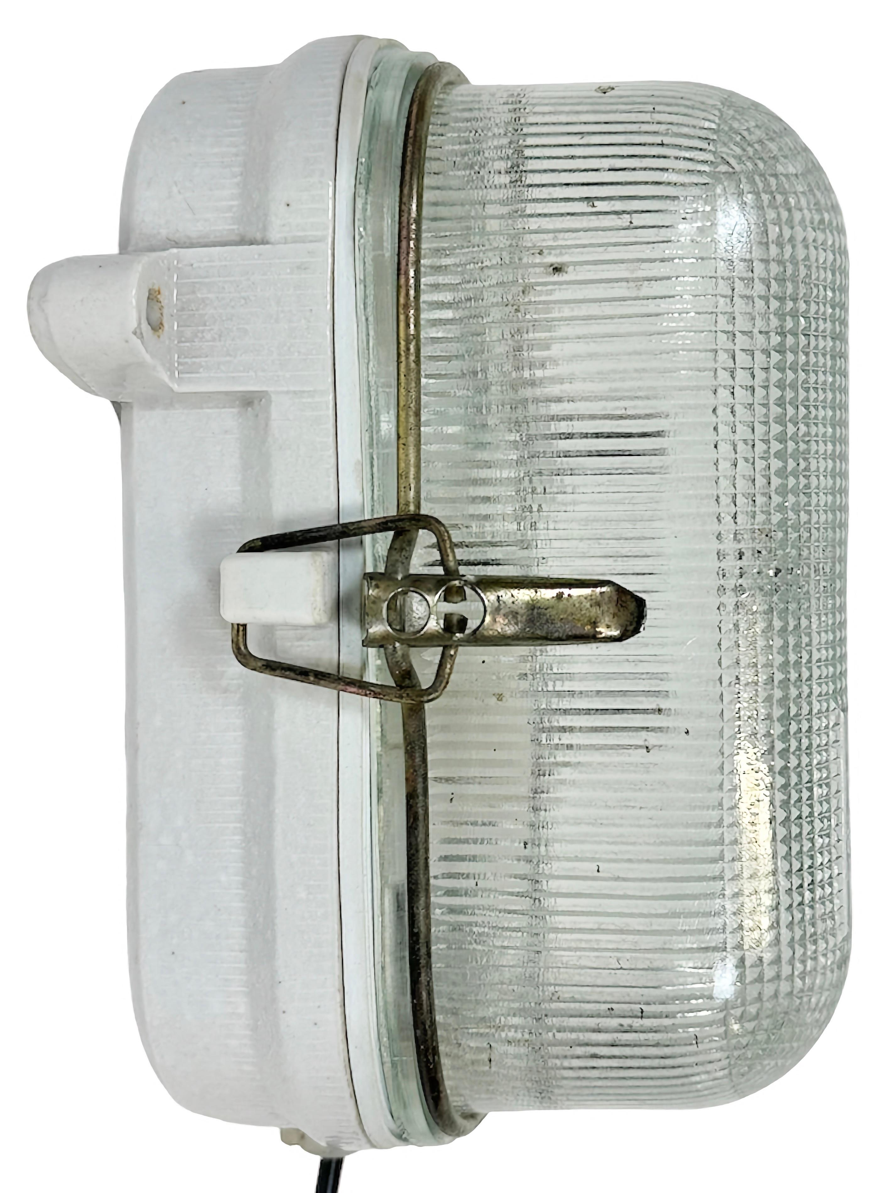 Vintage-Industrieleuchte, hergestellt in der ehemaligen Sowjetunion in den 1970er Jahren, mit weißem Porzellankörper und gerippter Glasabdeckung. Die Fassung benötigt E27/E26-Glühbirnen. Neues Kabel. Das Gewicht der Leuchte beträgt 2 kg.