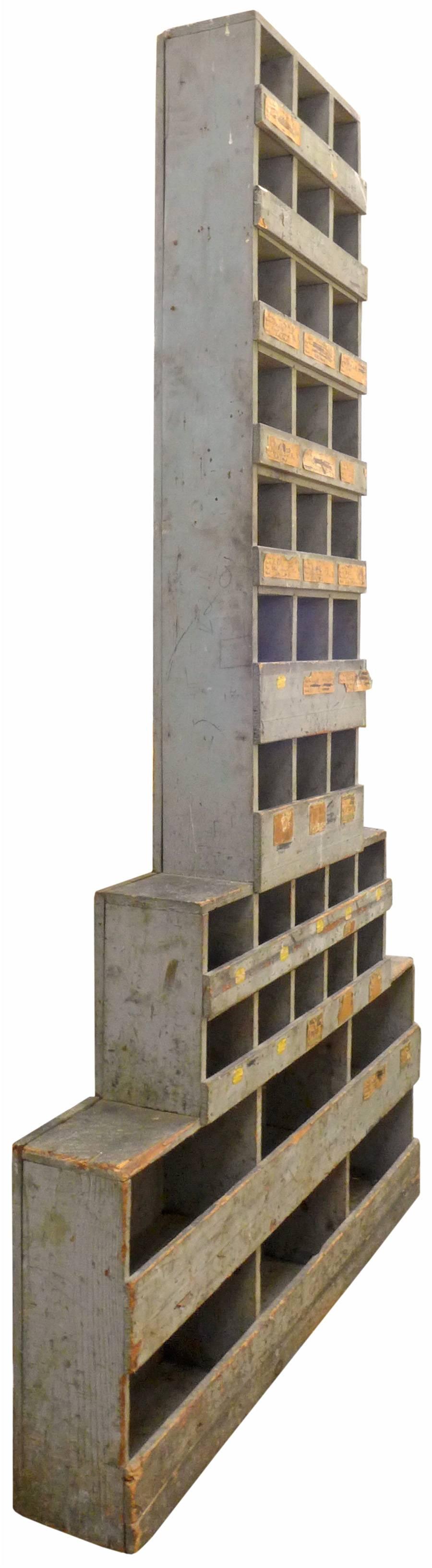 Un cabinet de gratte-ciel spectaculaire, haut et étagé, inspiré de l'âge de la machine. Primitive mais d'inspiration architecturale, cette forme inhabituelle était probablement utilisée à l'origine pour ranger le matériel d'une quincaillerie ou d'un