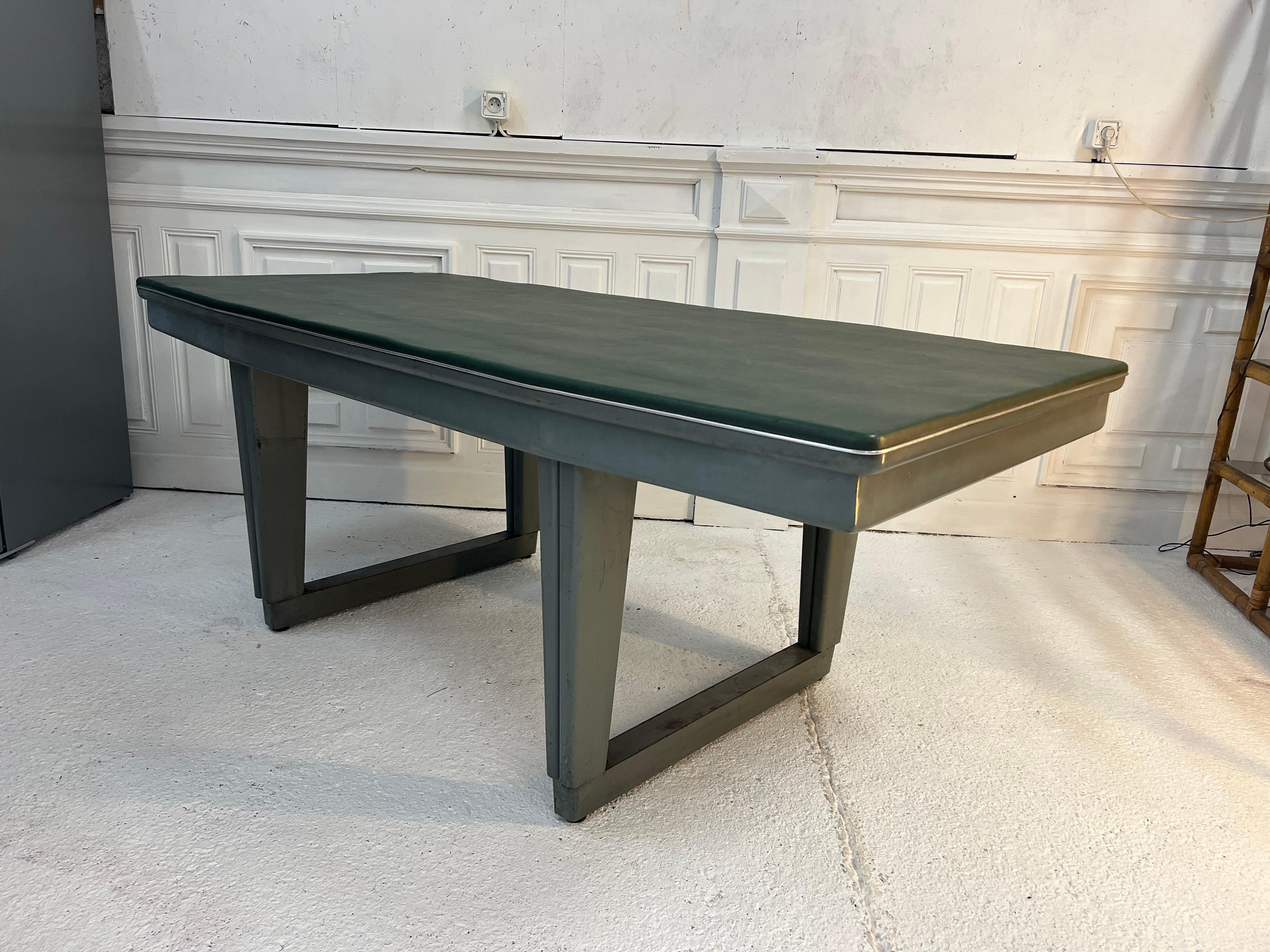 Arge industrial table with its original gray lacquered metal base and its top covered with green moleskin
The tray is octagonal in shape which gives it a softer side and easy to install in your interior.
The origin of the table was a sorting table