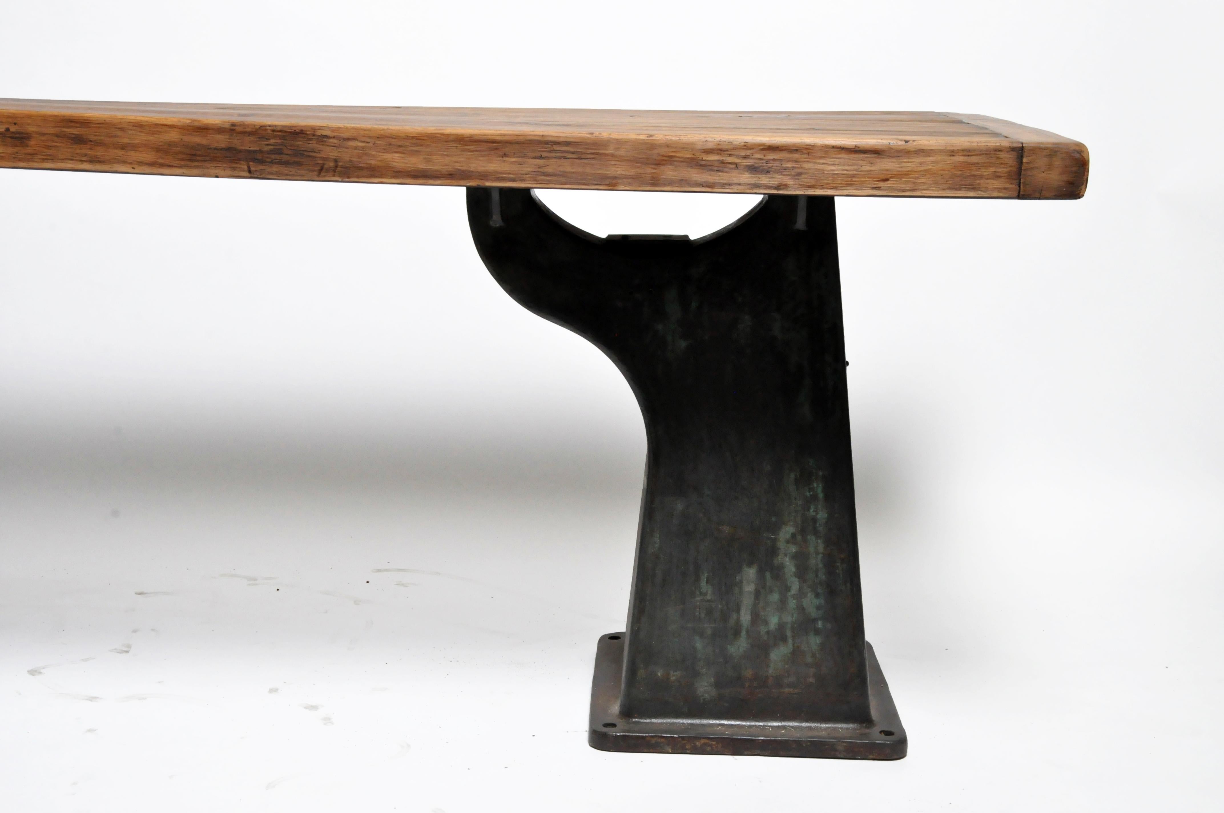 Acquired from a market in France, this massive Industrial work table features two metal bases, a wood top, and a metal plate with the stamp 