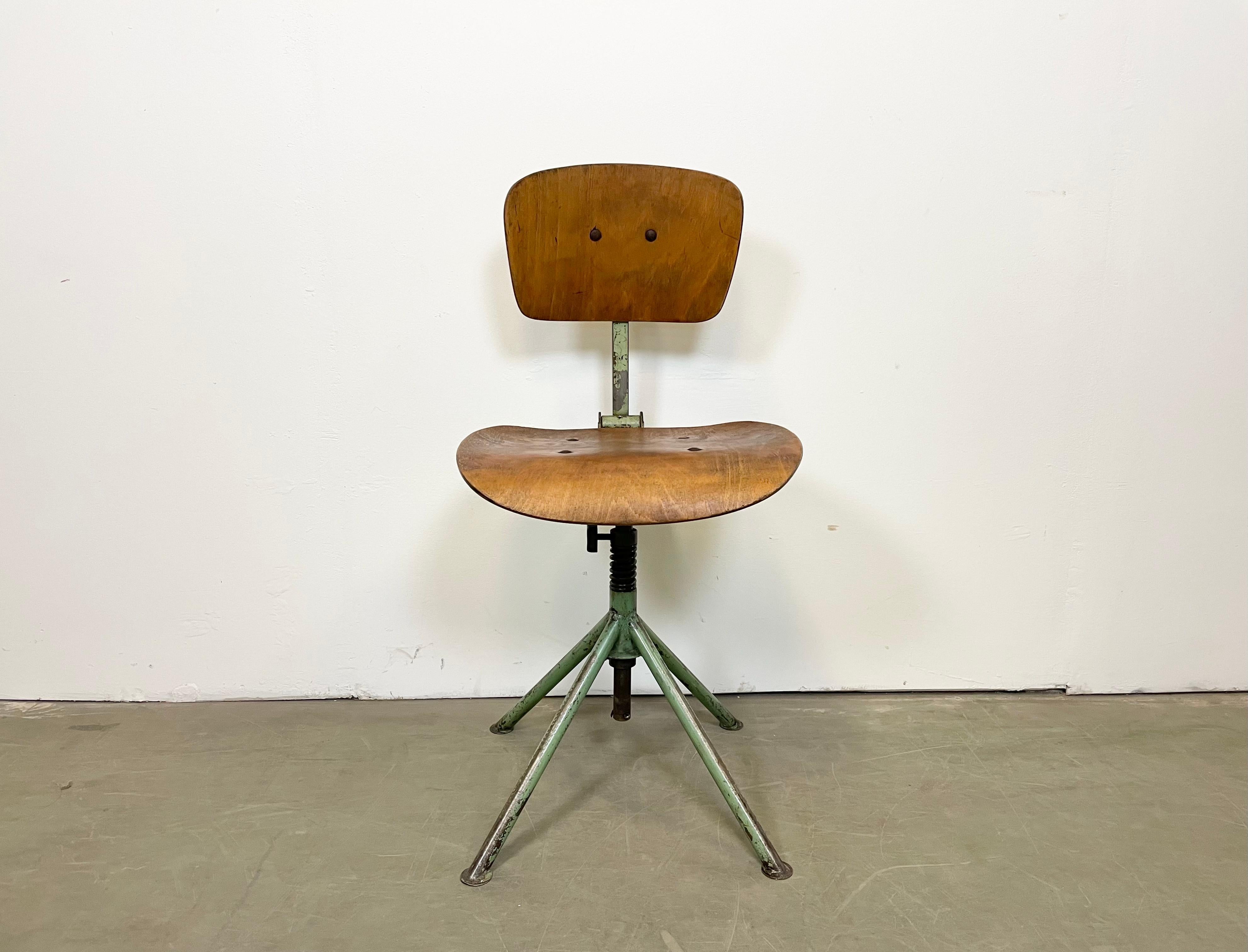 Dieser höhenverstellbare, drehbare Industriestuhl wurde in den 1950er Jahren in der ehemaligen Tschechoslowakei hergestellt und besteht aus einer Eisenkonstruktion sowie einer Sitzfläche und Rückenlehne aus Sperrholz. Das Gewicht des Stuhls beträgt