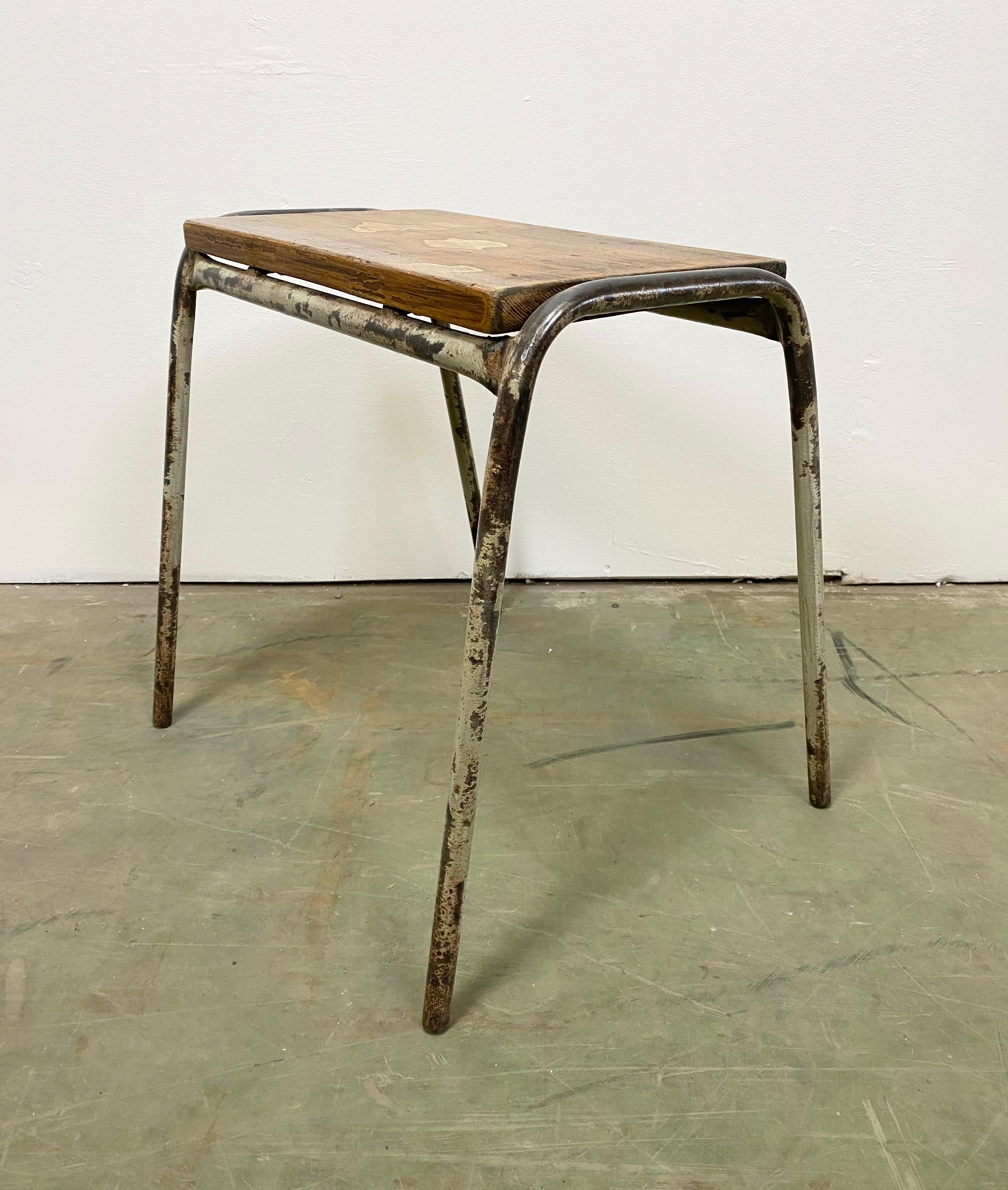 This industrial stool was made in the 1960s. It features an iron frame structure and a wooden seat. The stool has an age-related patina, it has been partly restored and remains in a good vintage condition with normal traces of use.
The weight of