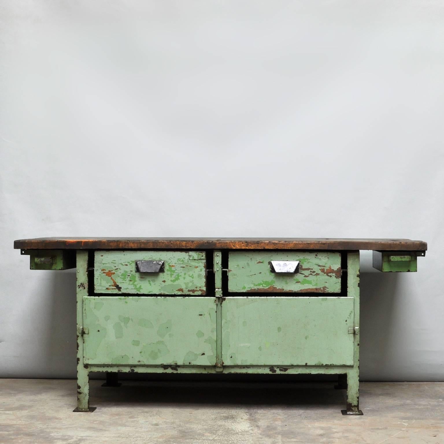 Heavy industrial worktable from the 1950s, produced in the Czech Republic. The worktable is made of iron with a wooden top and drawers. The table is treated for rust and finished with a transparent lacquer.