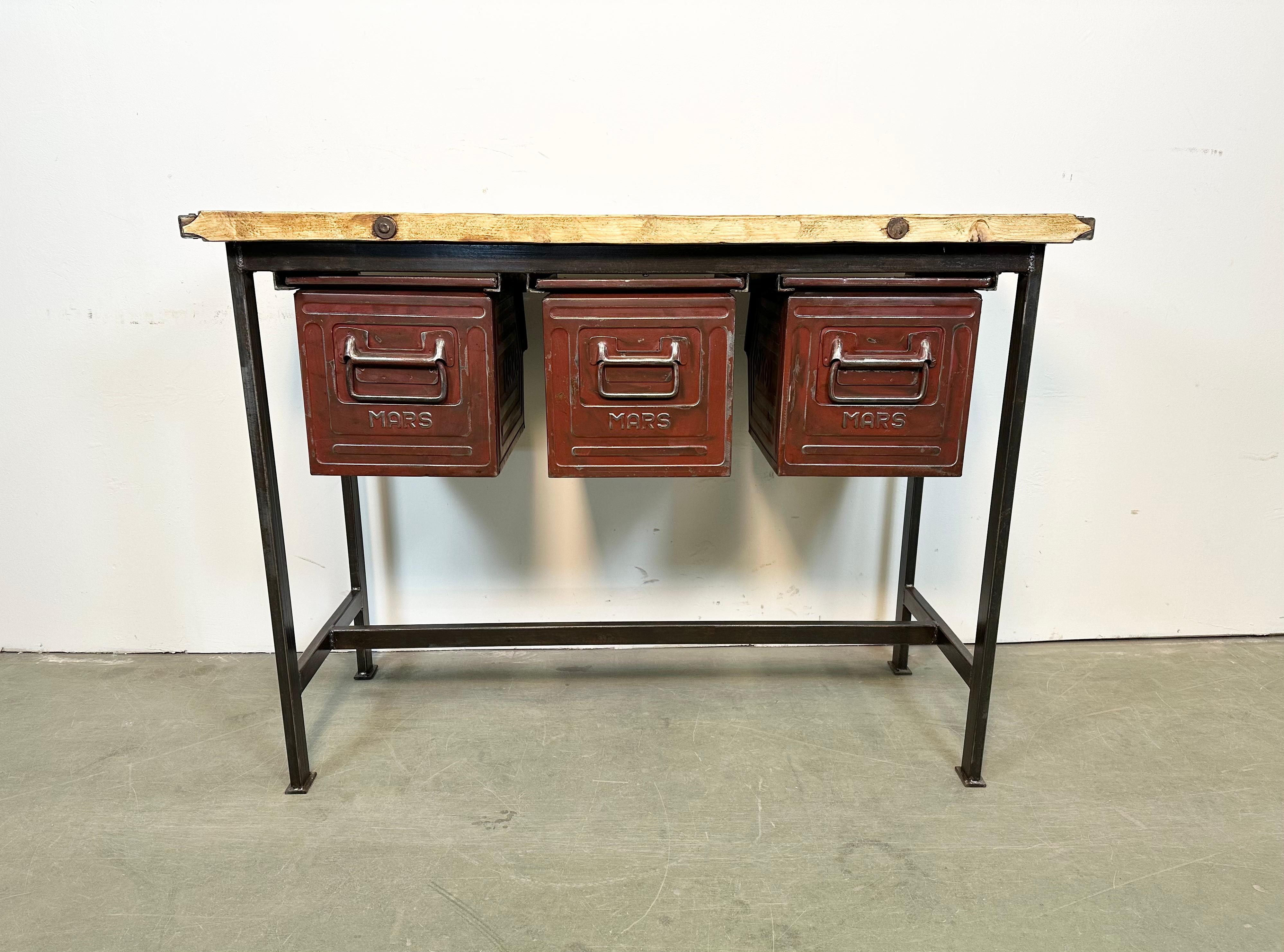 Vintage industrial worktable from the 1960s. It features a black iron construction, solid wooden plate and three red iron drawers. Weight: 41 kg.
Drawer dimensions:
Width: 28 cm
Depth: 39 cm
Height: 30 cm