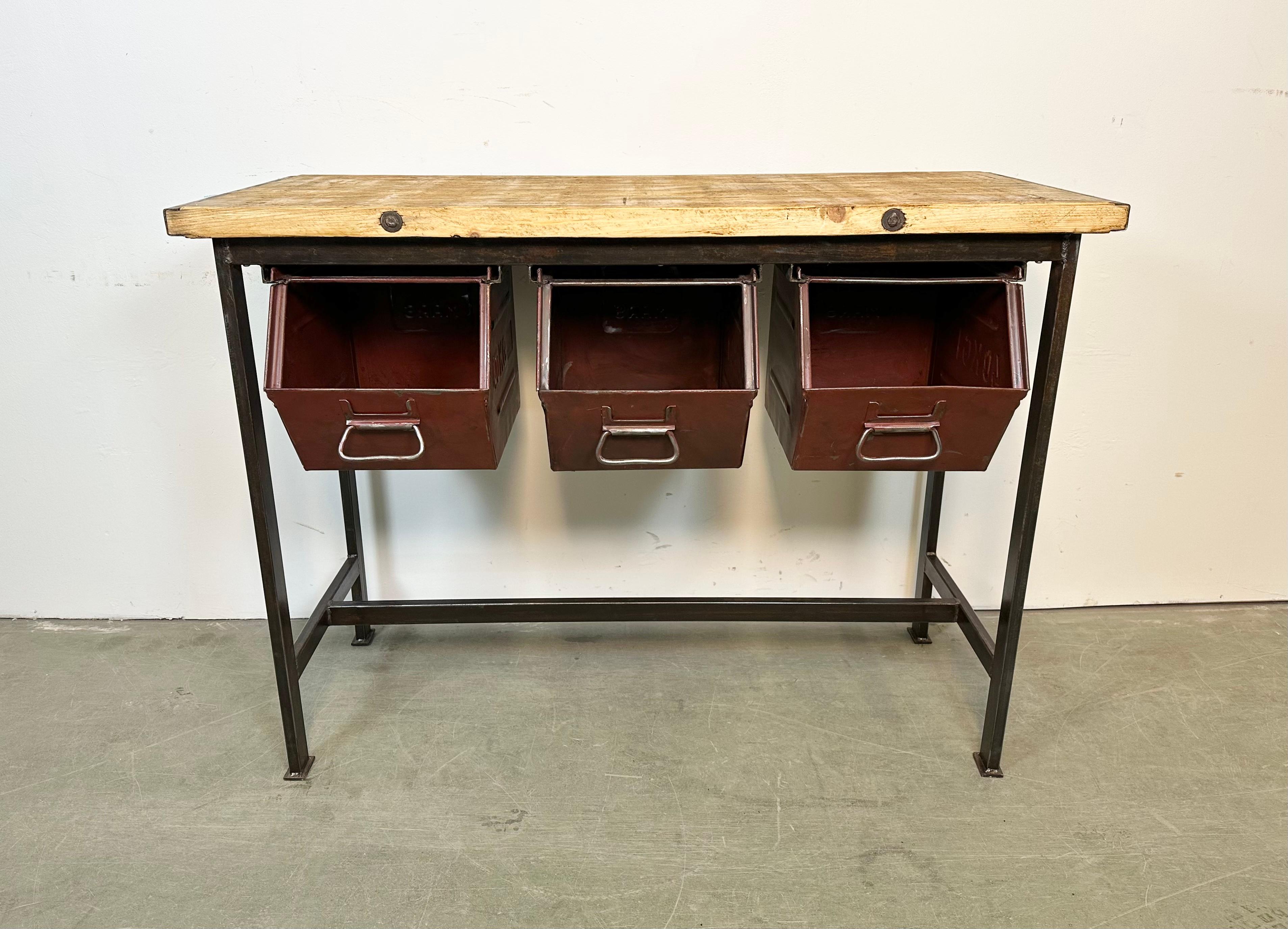 Vintage industrial worktable from the 1960s. It features a black iron construction, solid wooden plate and three red iron drawers. Weight: 41 kg.
Drawer dimensions:
Width: 28 cm
Depth: 39 cm
Height: 30 cm.