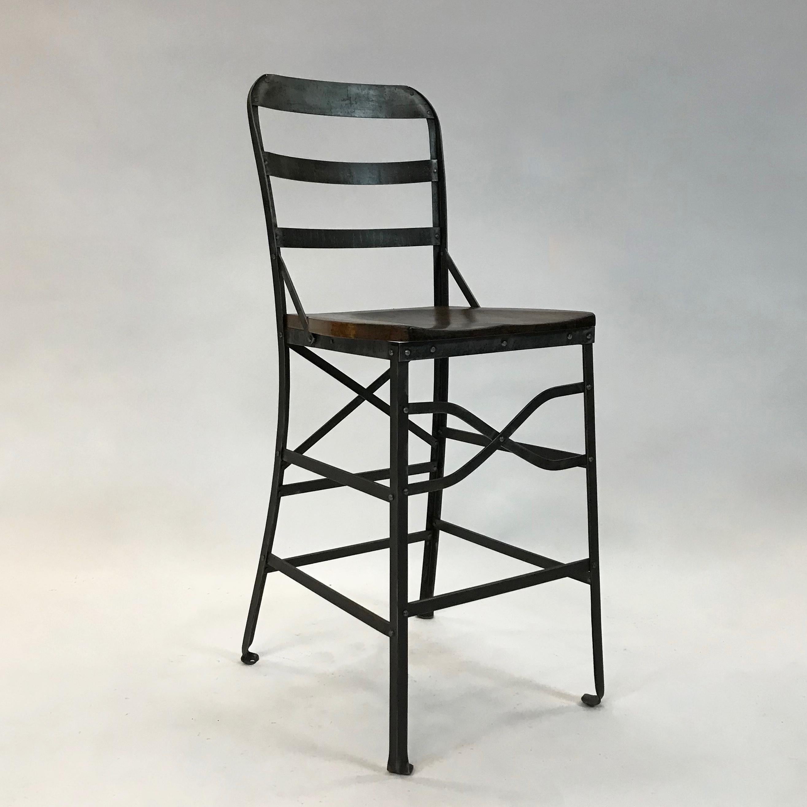 Industrial, counter height, shop stool features a wrought iron frame and contoured oak seat.