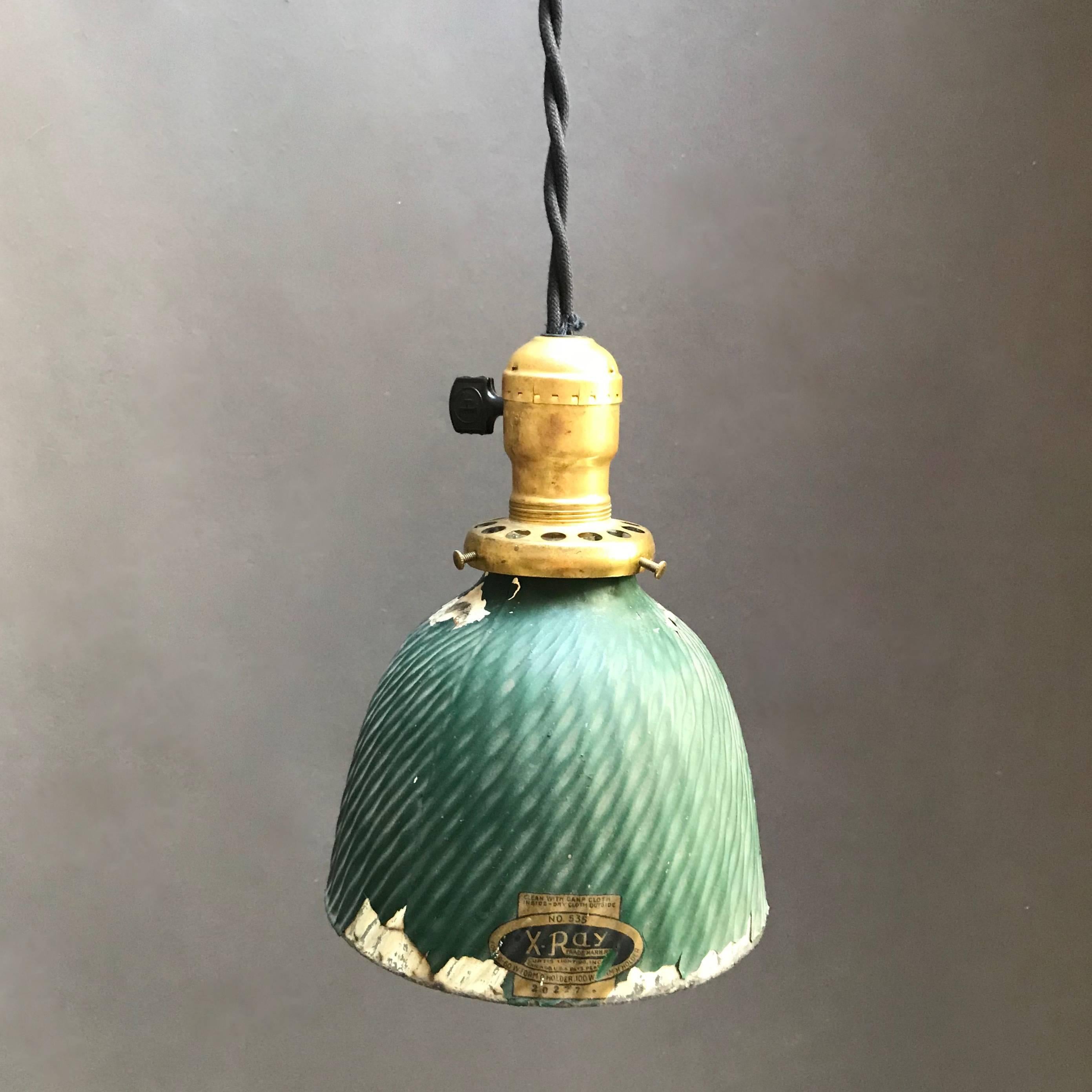 Industrial, factory pendant light features an X-Ray mercury glass dome shade with painted green exterior and brass switch fitter. The pendant is newly wired with 36 inches of black braided cloth cord to accept up to a 150 watt bulb.