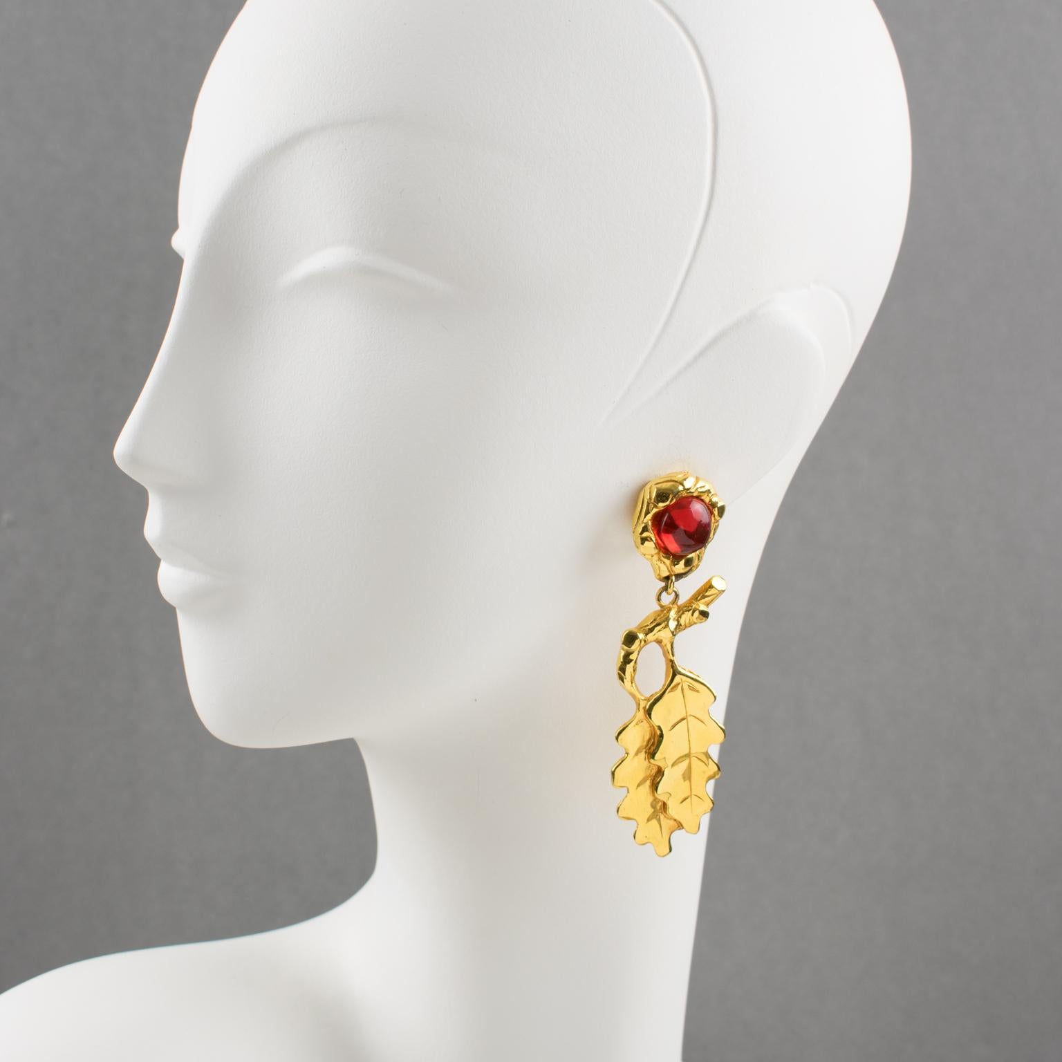 Oversized clip-on earrings by Ines de la Fressange Paris. Dangling shape, with gilt metal all carved and textured featuring oak leaves compliment with amber resin cabochon. Signed underside with Ines de la Fressange gilt logo tag: 