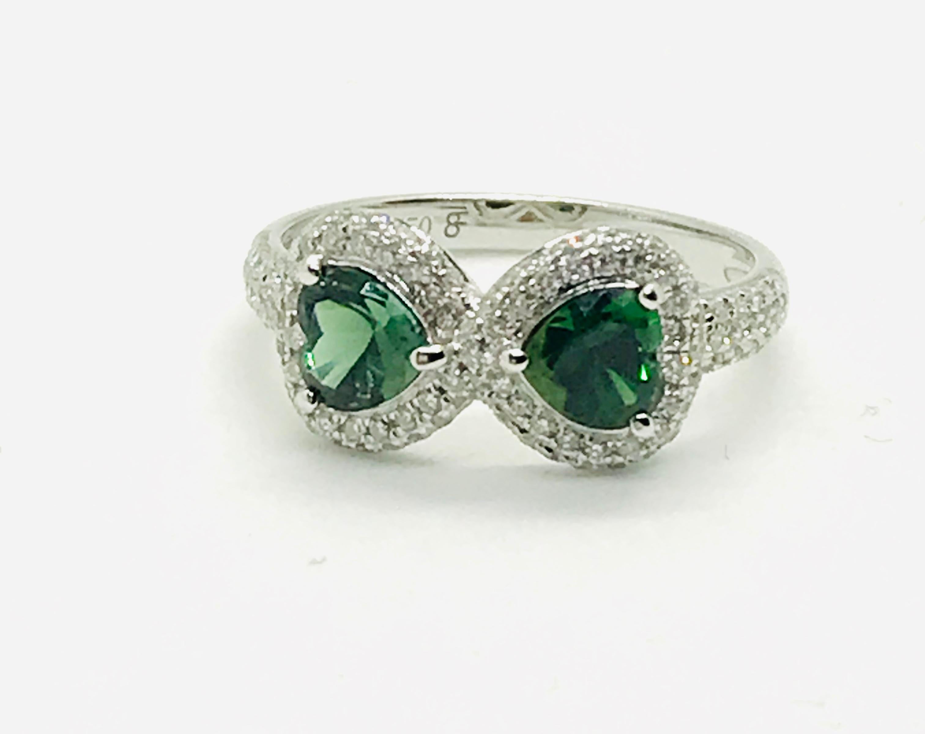A 18K White gold, diamonds (0,385 ct) and heart-shaped Green Tourmalines (0,91 ct).
Size 53.                 
“Infinite Eight of hearts” diamonds and colored stones rings carry deep meaning : number eight brings prosperity and luck : when