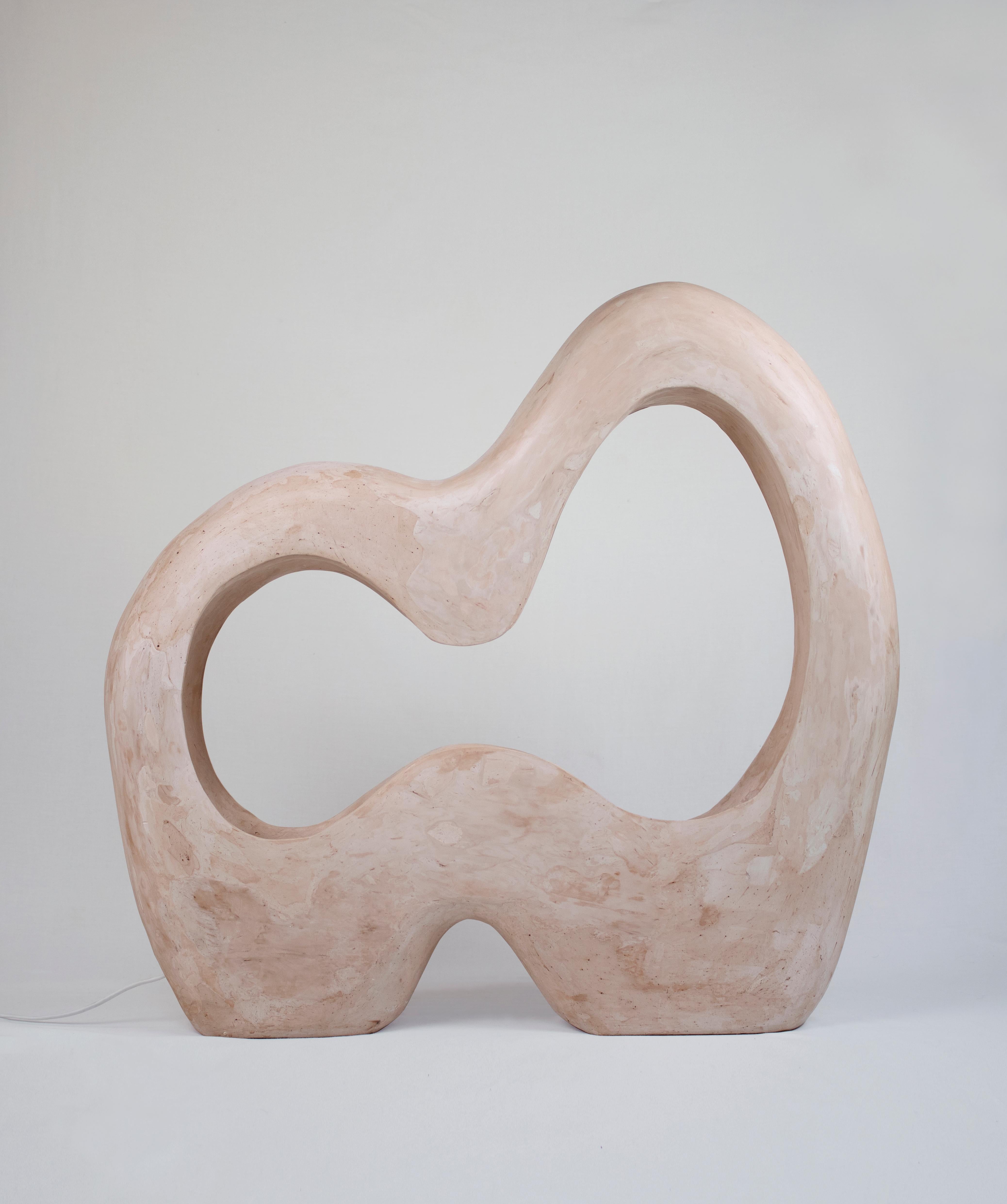 The Infinite Lamp is a contemporary handmade sculptural gypsum lamp part of the Living Forms collection. The lamp is cast in gypsum and carved by hand. The Infinite Lamp stands out as a stunning blend of fine art and functional design. It's a part