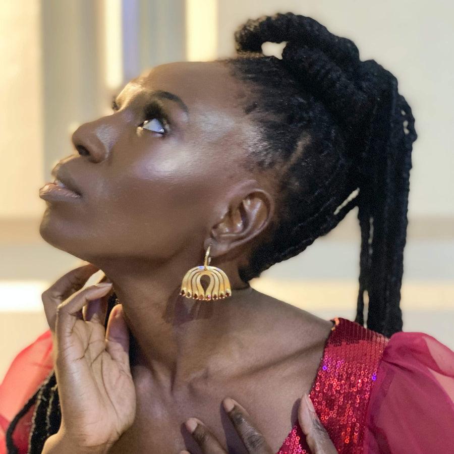 Embrace the detachable earrings showcasing a remarkable depiction of the peacock, a passionate artistic vision of these courageous birds. A cut-out pear in the center symbolizes strong will, empowerment, independence, and unique style with garnet