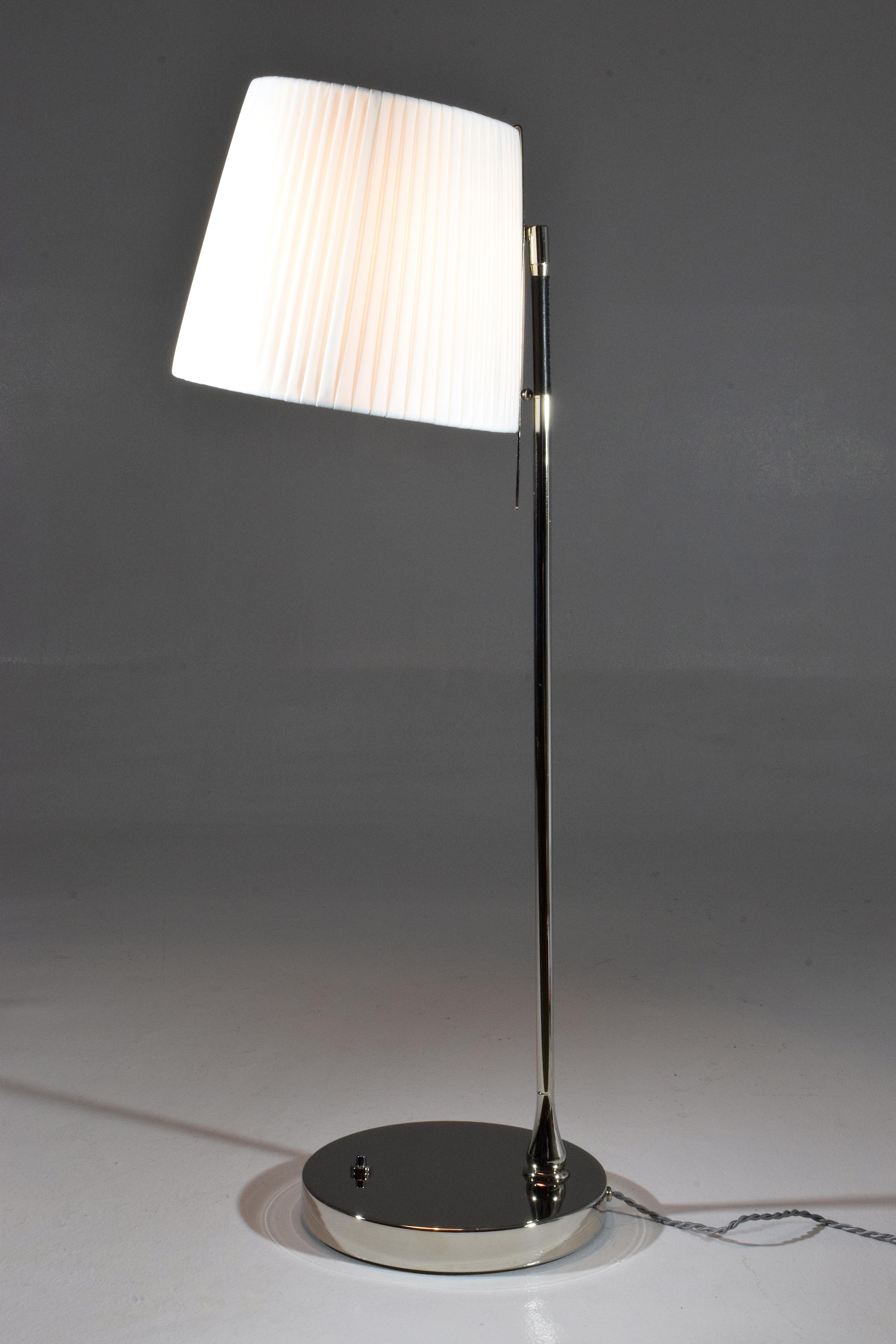 Contemporary handcrafted tall table lamp composed of a nickel-plated solid brass structure and adorned with a black hand-sewn sheathed leather detail. The fabric shade rotates at 90 degrees and is designed with a stem so you may orientate the light