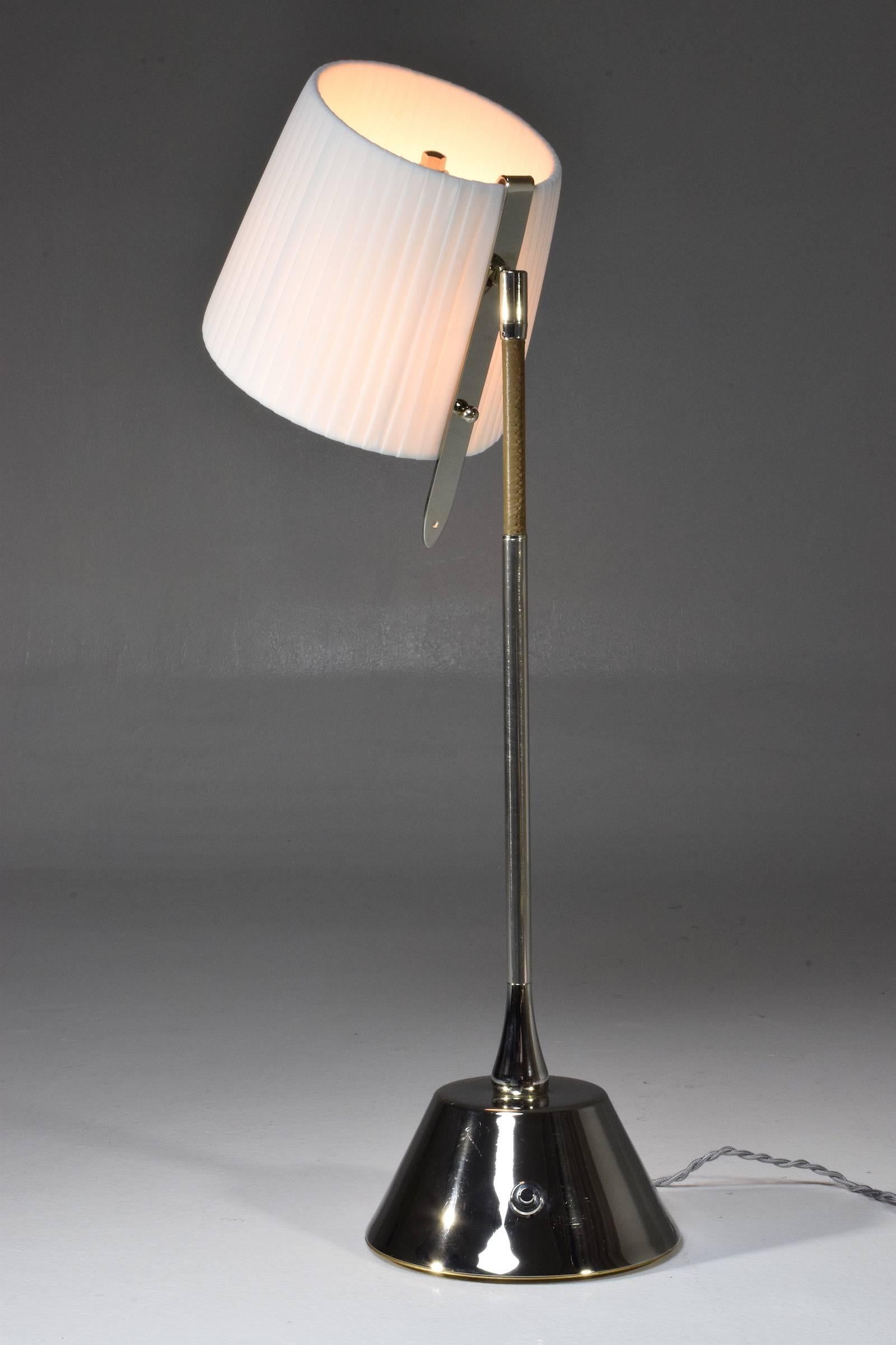 Contemporary handcrafted articulating table lamp of considerable size pictured in nickel silver plated polished brass finish adorned with a brown hand-sewn sheathed leather detail and designed with our signature pear-shaped joint . The shade is