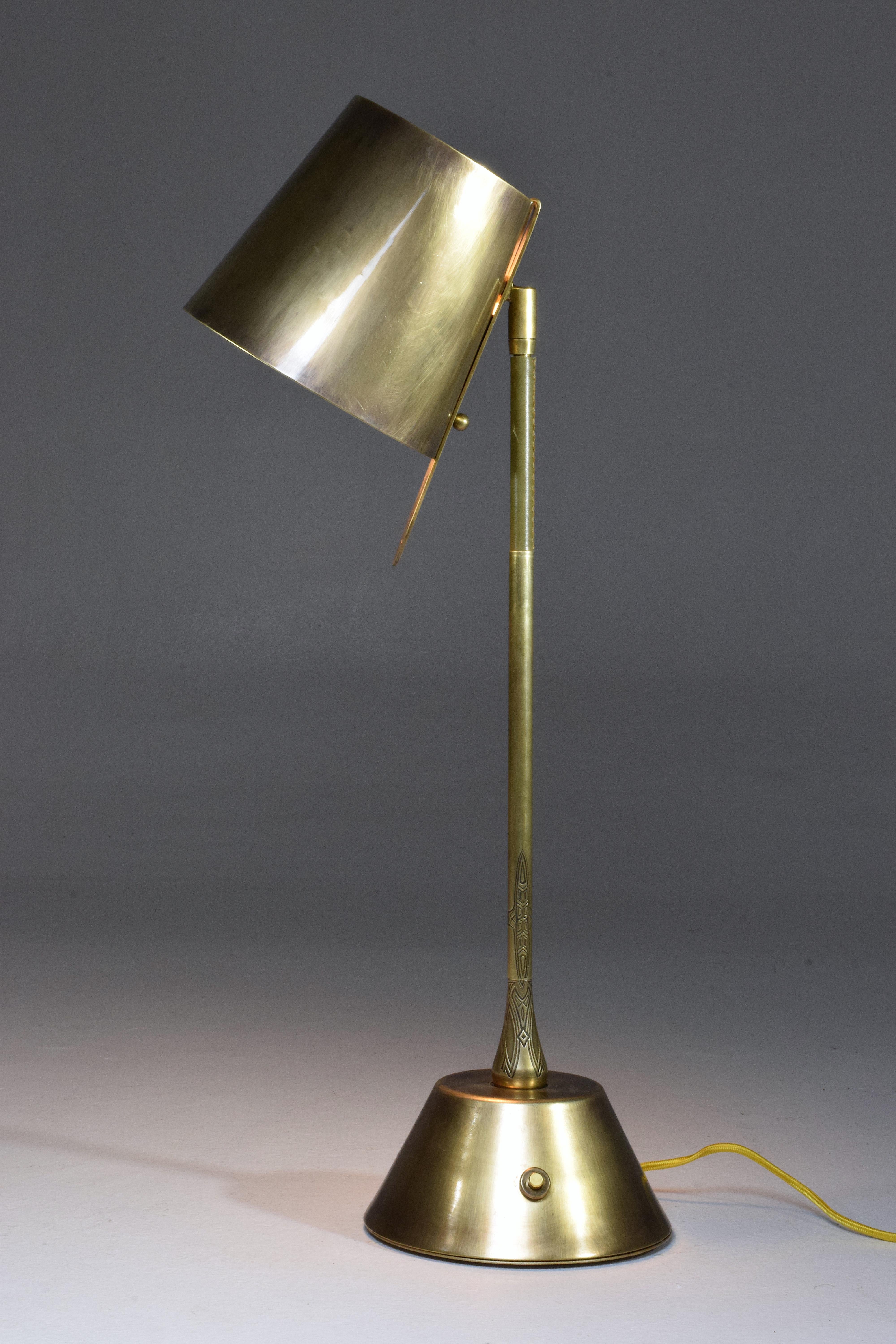 Contemporary handcrafted articulating table lamp of considerable size pictured in a solid polished aged brass finish, adorned with a brown hand-sewn sheathed leather detail and designed with our signature pear shaped joint. The shade is built with a