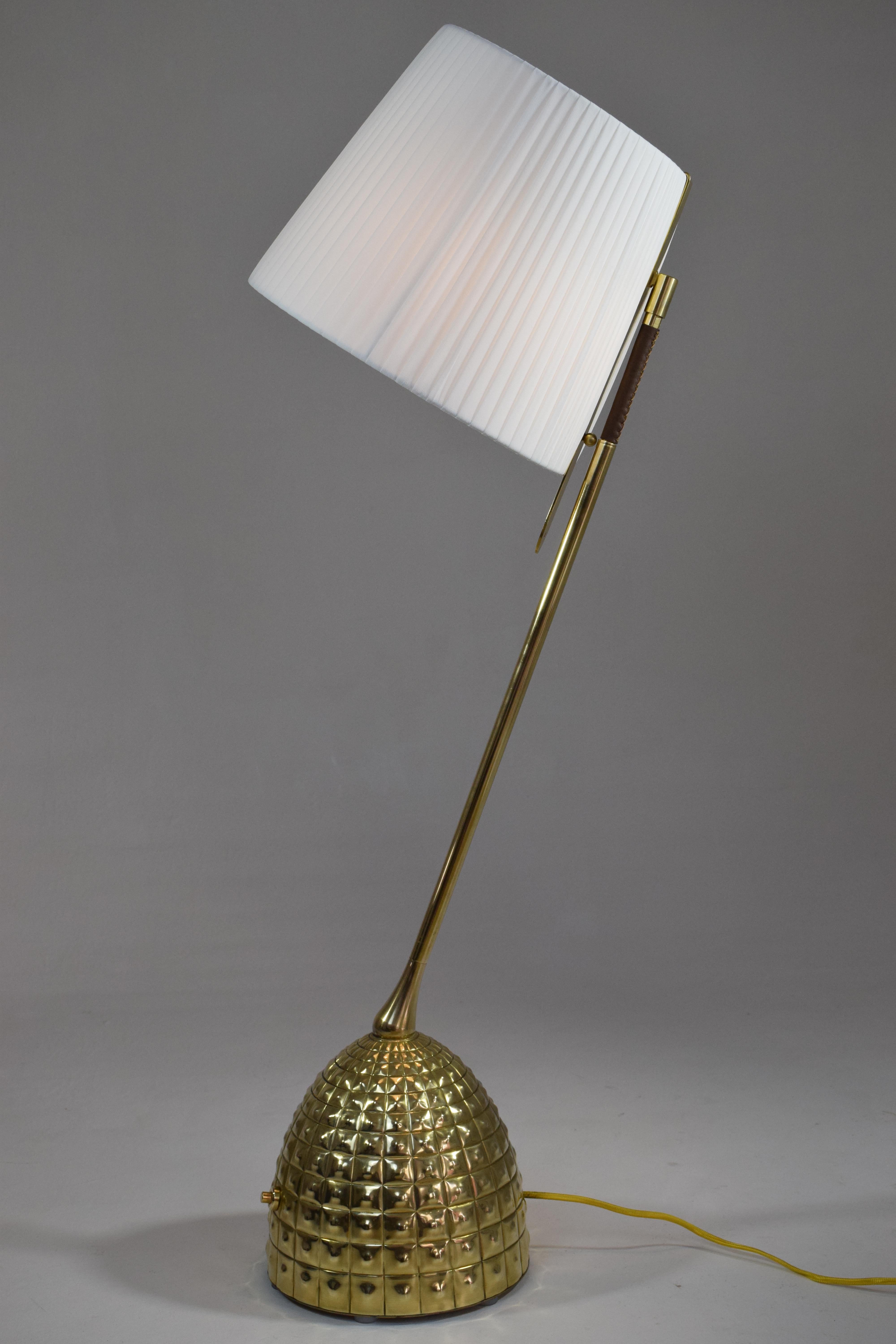 Contemporary handcrafted articulating table lamp of considerable size in solid gold polished brass and a hand sewn sheathed leather detail, intricately hand embellished base and designed with our signature pear-shaped joint. The shade is built with