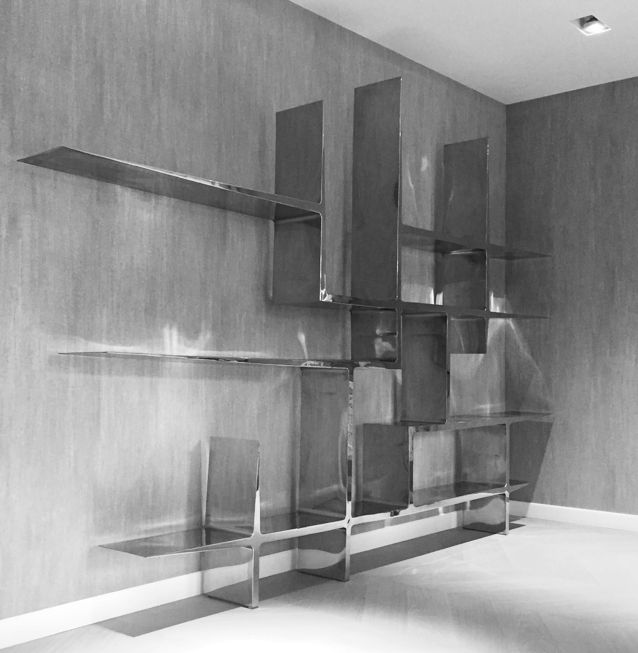 Libreria Infinity di Pol Quadens 
Edizione limitata di 8+4 pezzi.
Dimensioni: D 30 x L 420 x H 360 cm.
Materiali: Acciaio inossidabile lucidato.

Pol Quadens è nato a Bruxelles. Suo padre era attivo nel campo dei compositi e dell'industria