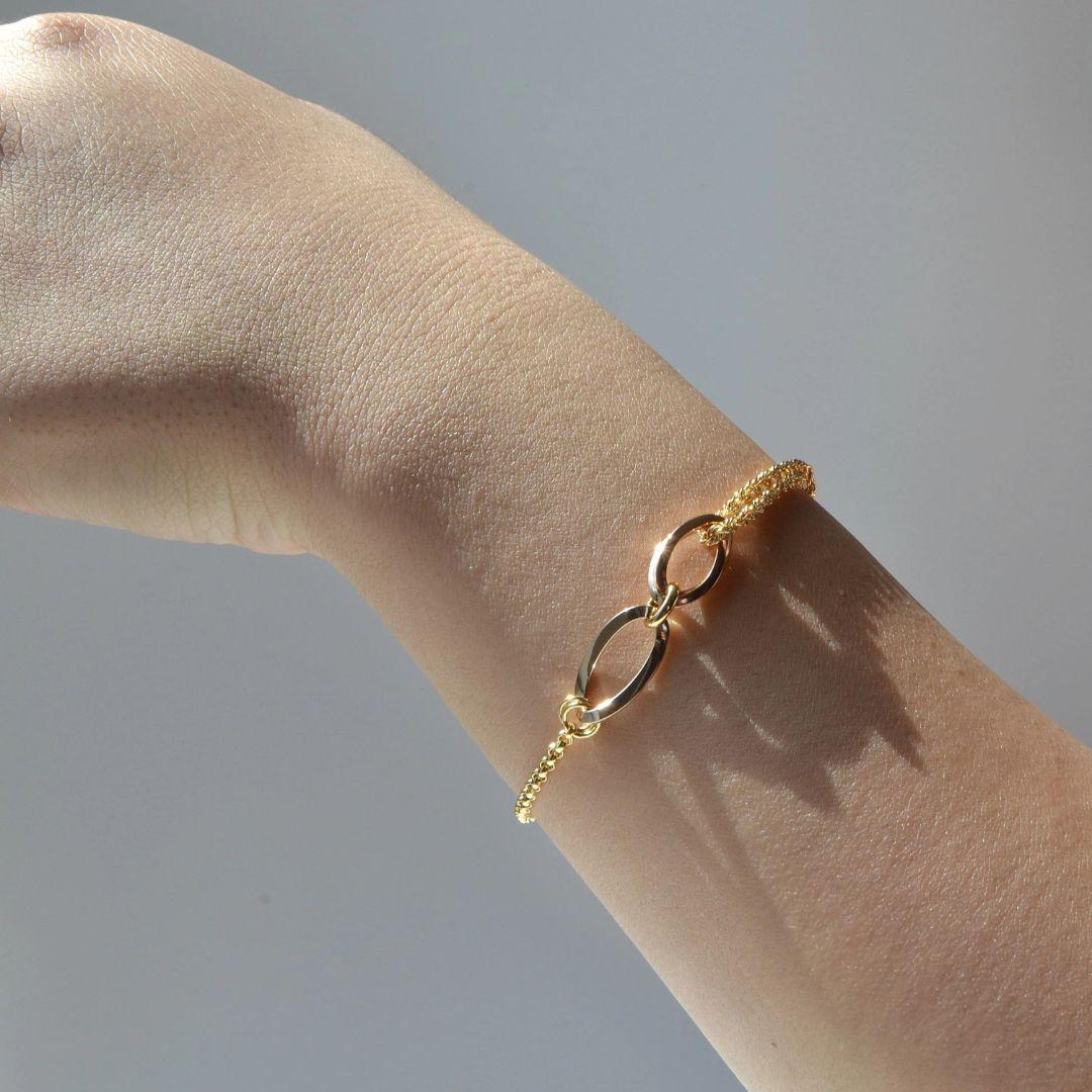Delicada pero distintiva, esta pulsera de oro de 18 quilates presenta un elegante dúo de eslabones de oro rosa pulido y oro amarillo en su centro. Los tonos contrastados están bellamente equilibrados por dos finas cadenas, creando una silueta