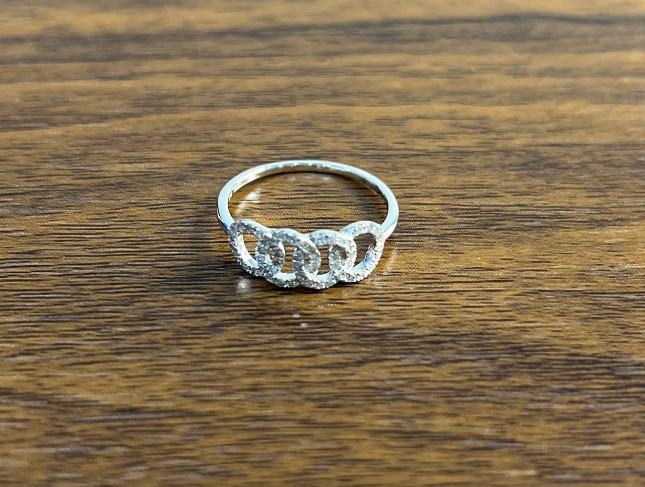 This exquisite piece features a delicate band adorned with interlocking circles. Each circle is encrusted with shimmering diamonds, creating a captivating sparkle. The design is both modern and elegant, with a focus on intricate detailing.
0.31 ctw